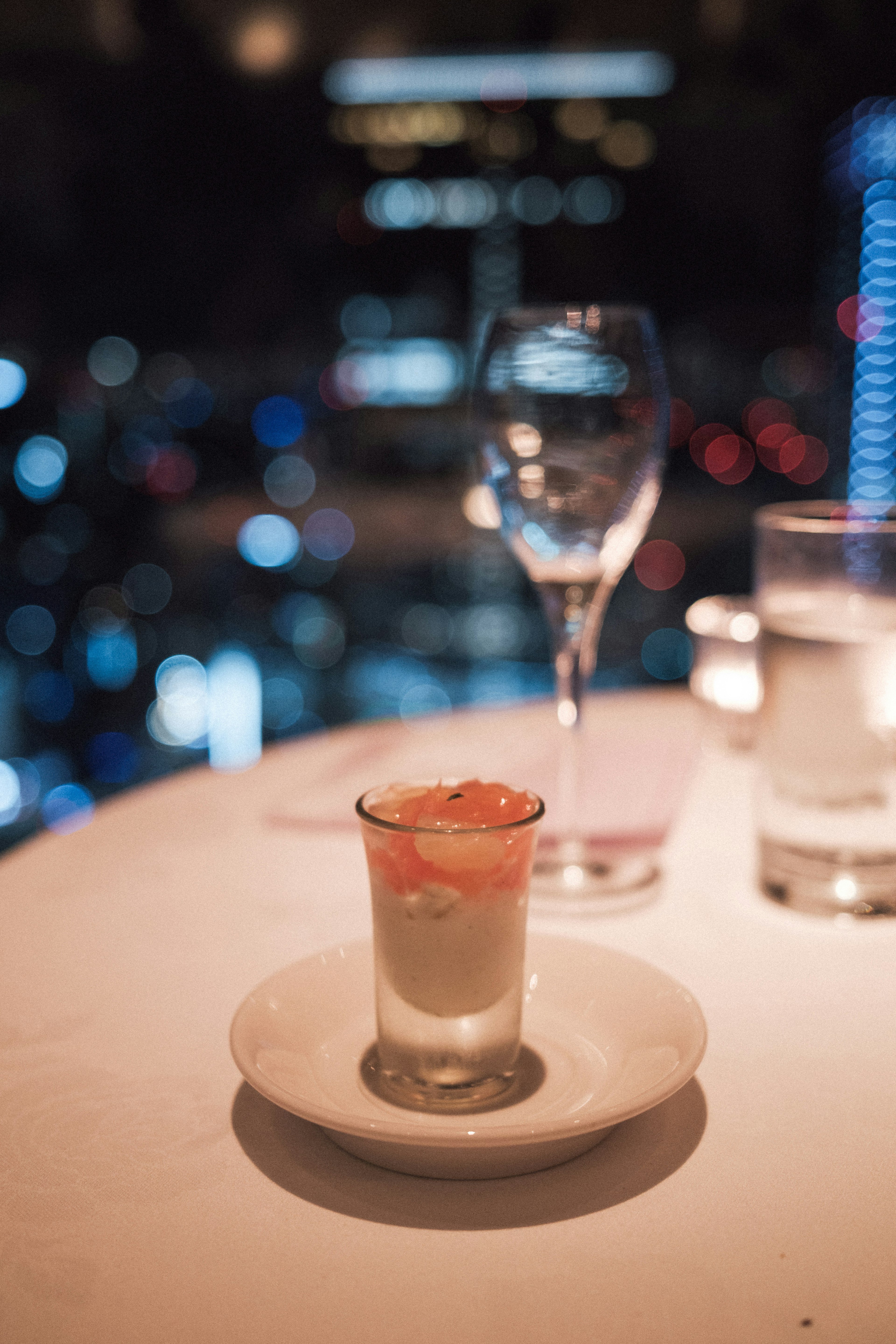 Bicchierino di dessert con sfondo di skyline cittadino e bicchiere di vino