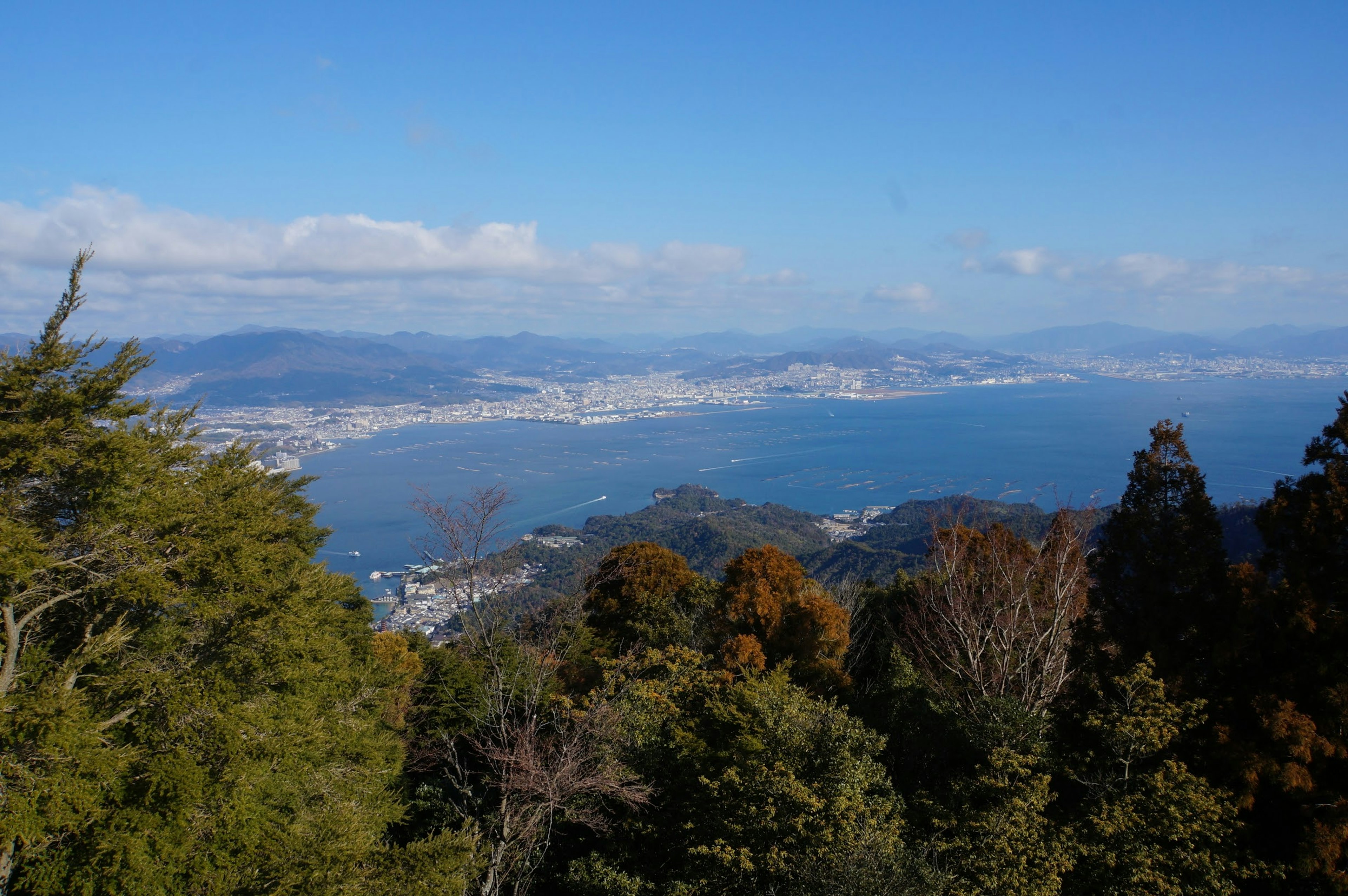 Panoramablick auf Berge und blauen Ozean unter klarem Himmel