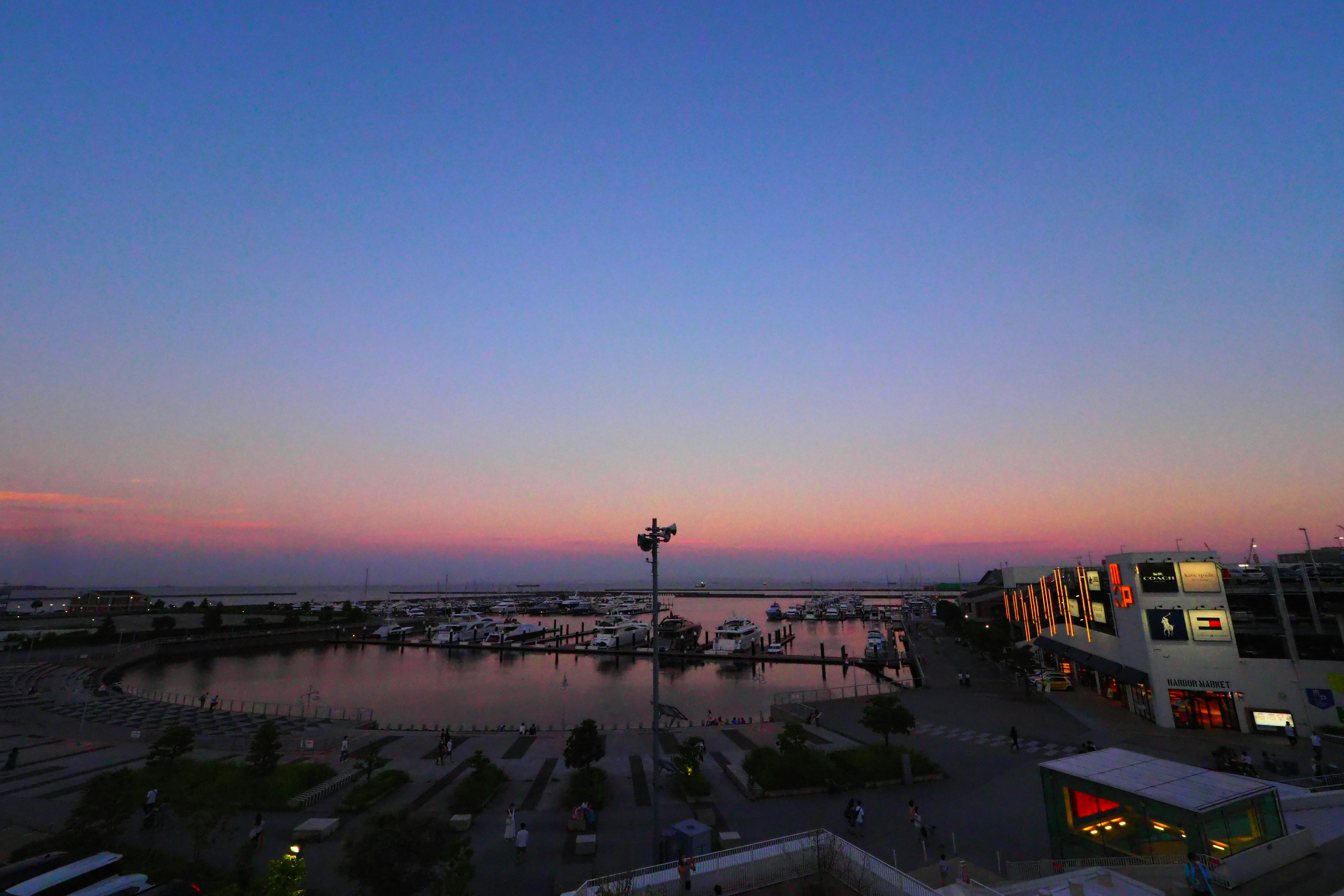 Vue au crépuscule d'un port avec des silhouettes de bâtiments