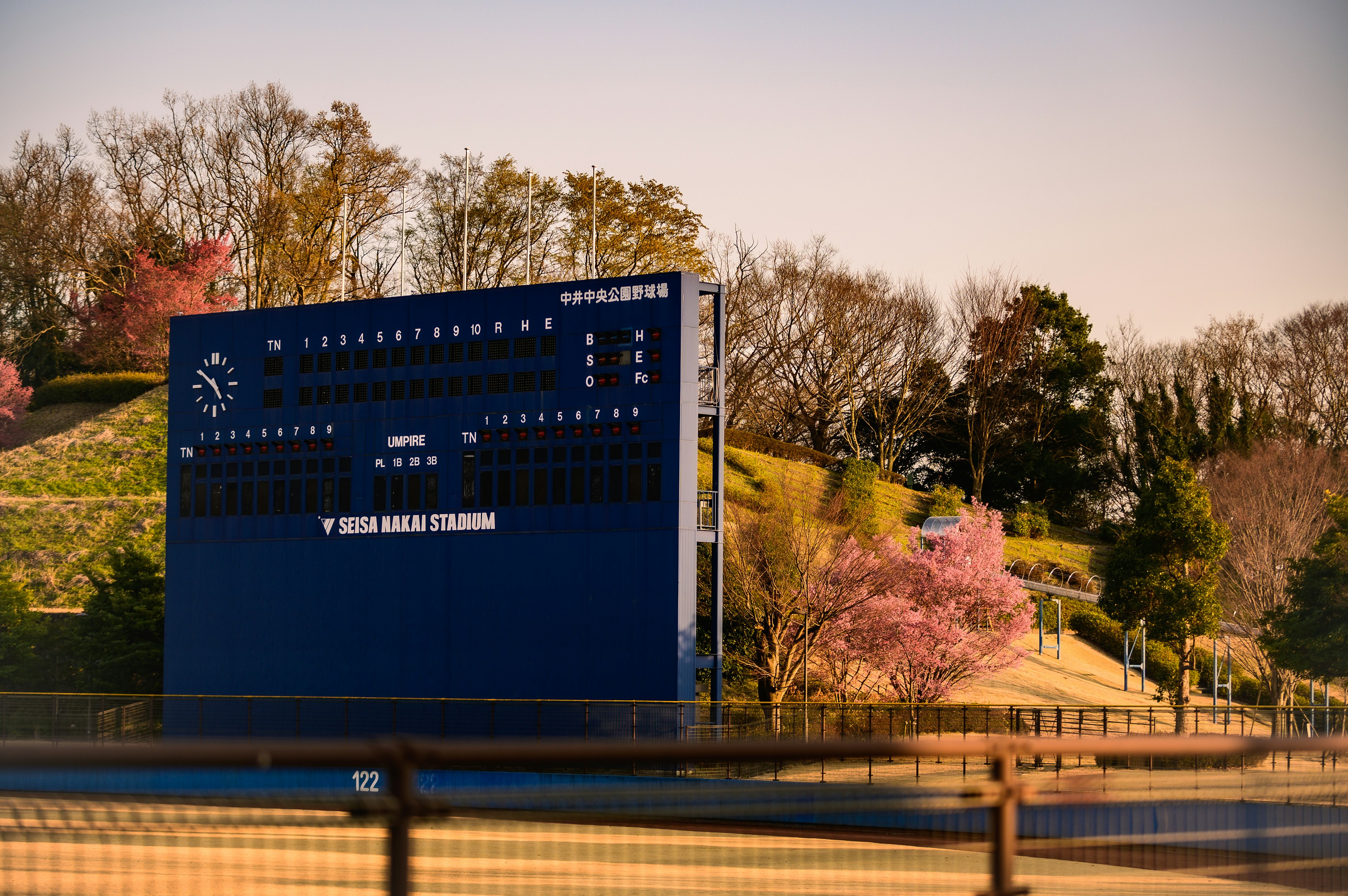 Baseball-Scoreboard mit Kirschbäumen im Hintergrund