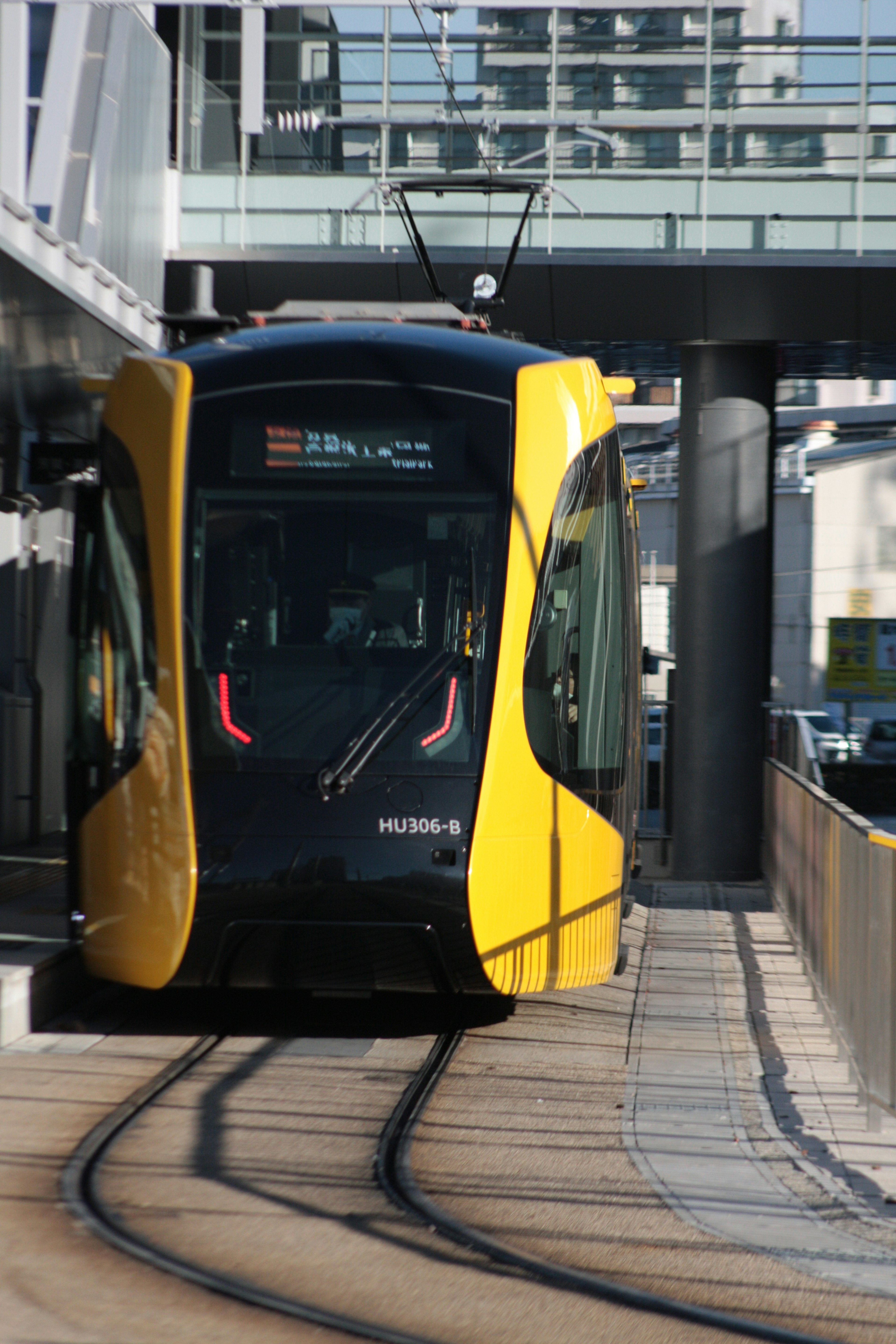 黄色と黒のトラムが駅に停車している風景