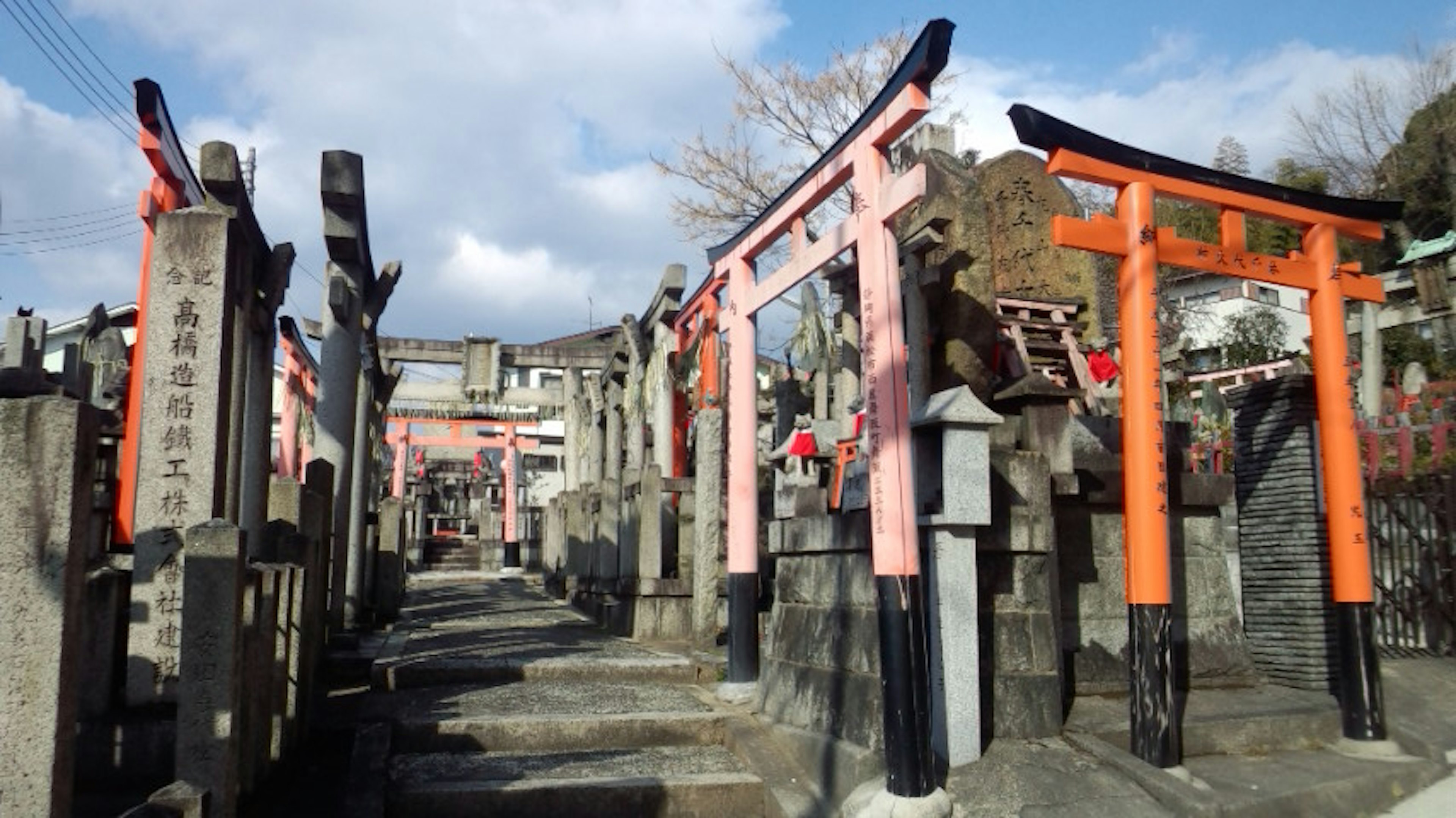 一條兩旁有紅色鳥居和石頭結構的神社小道