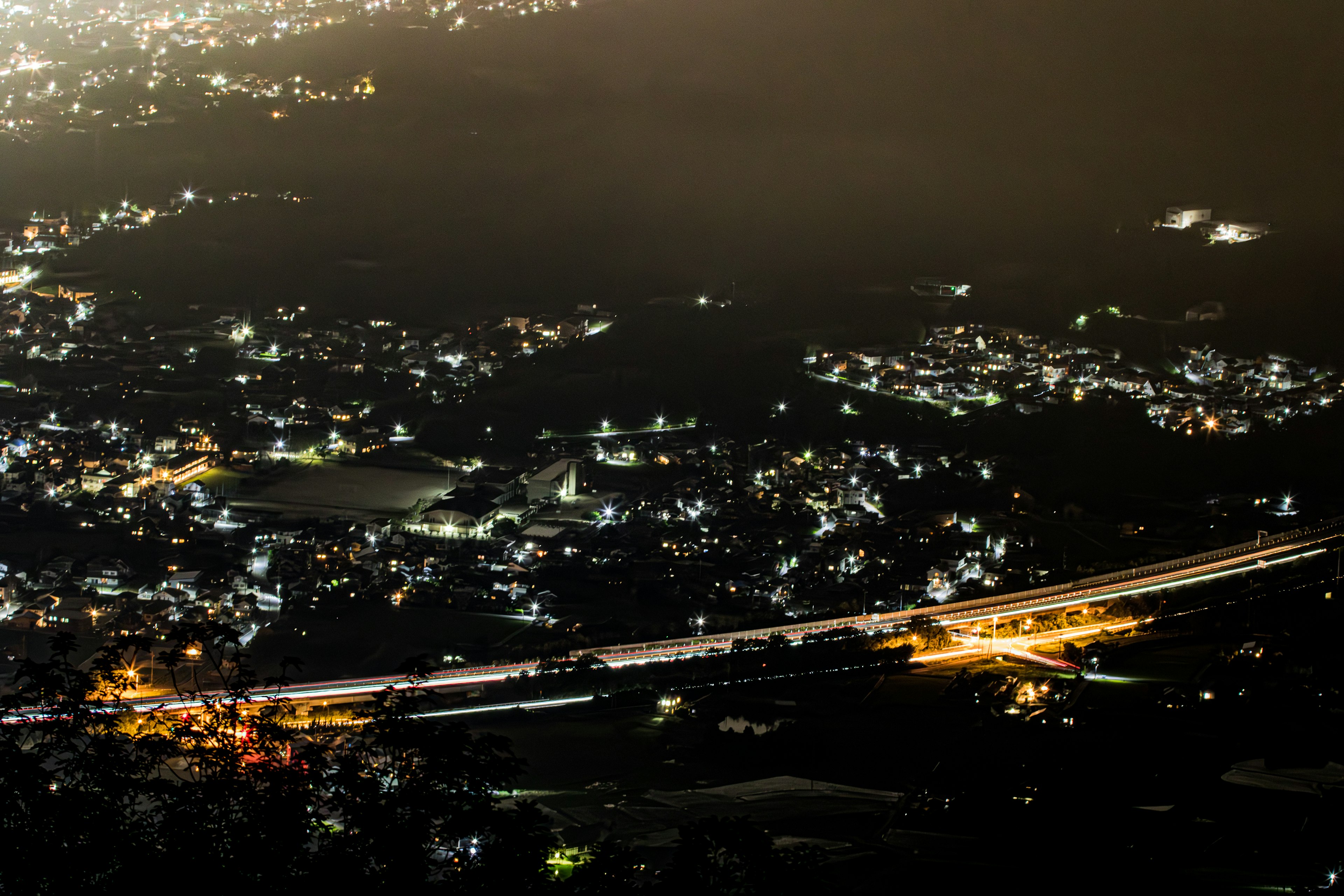 Nachtansicht einer Stadt mit einer Autobahn Helle Straßenlichter und verstreute Autolichter