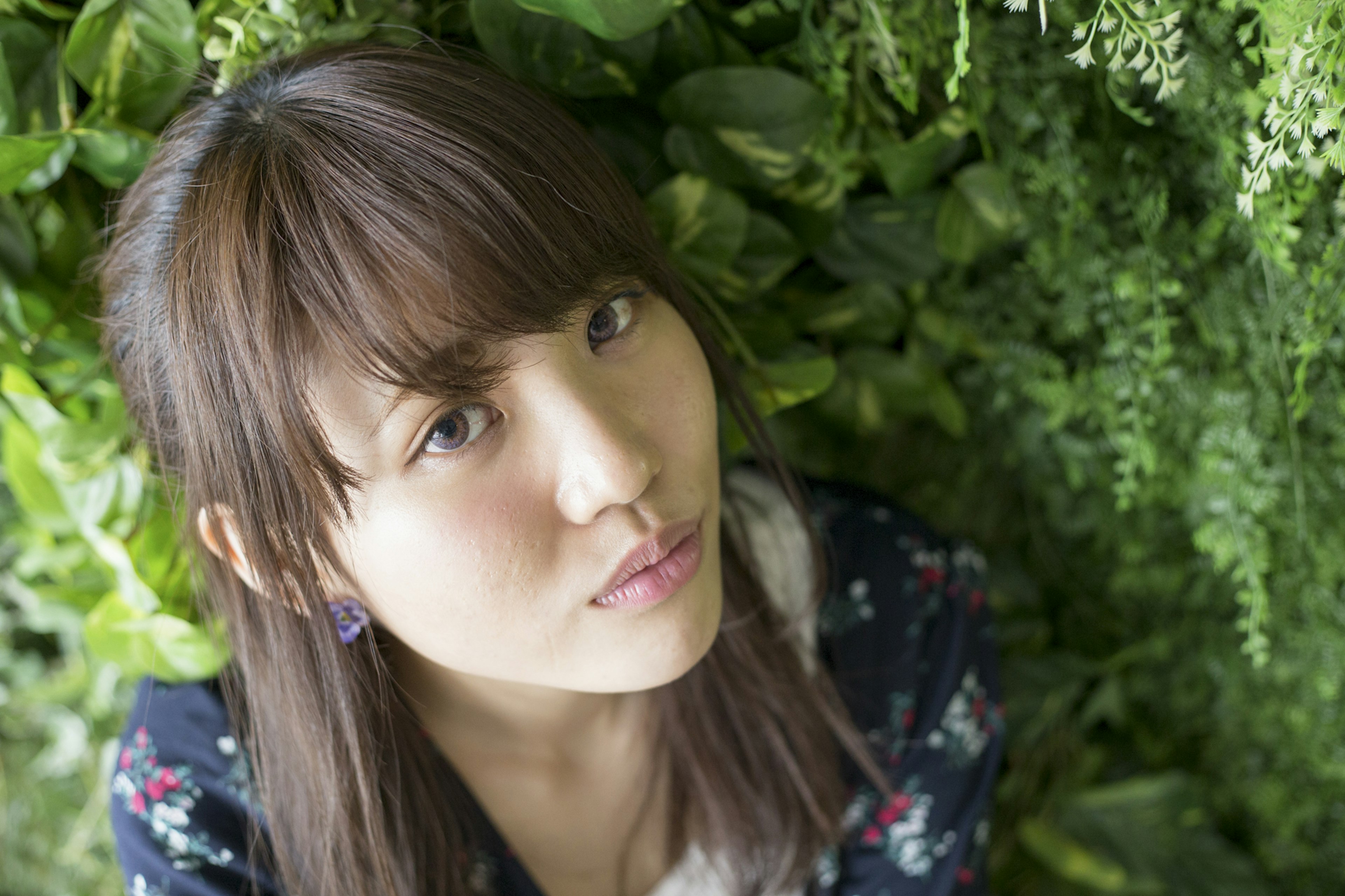 緑の植物に囲まれた女性のポートレート