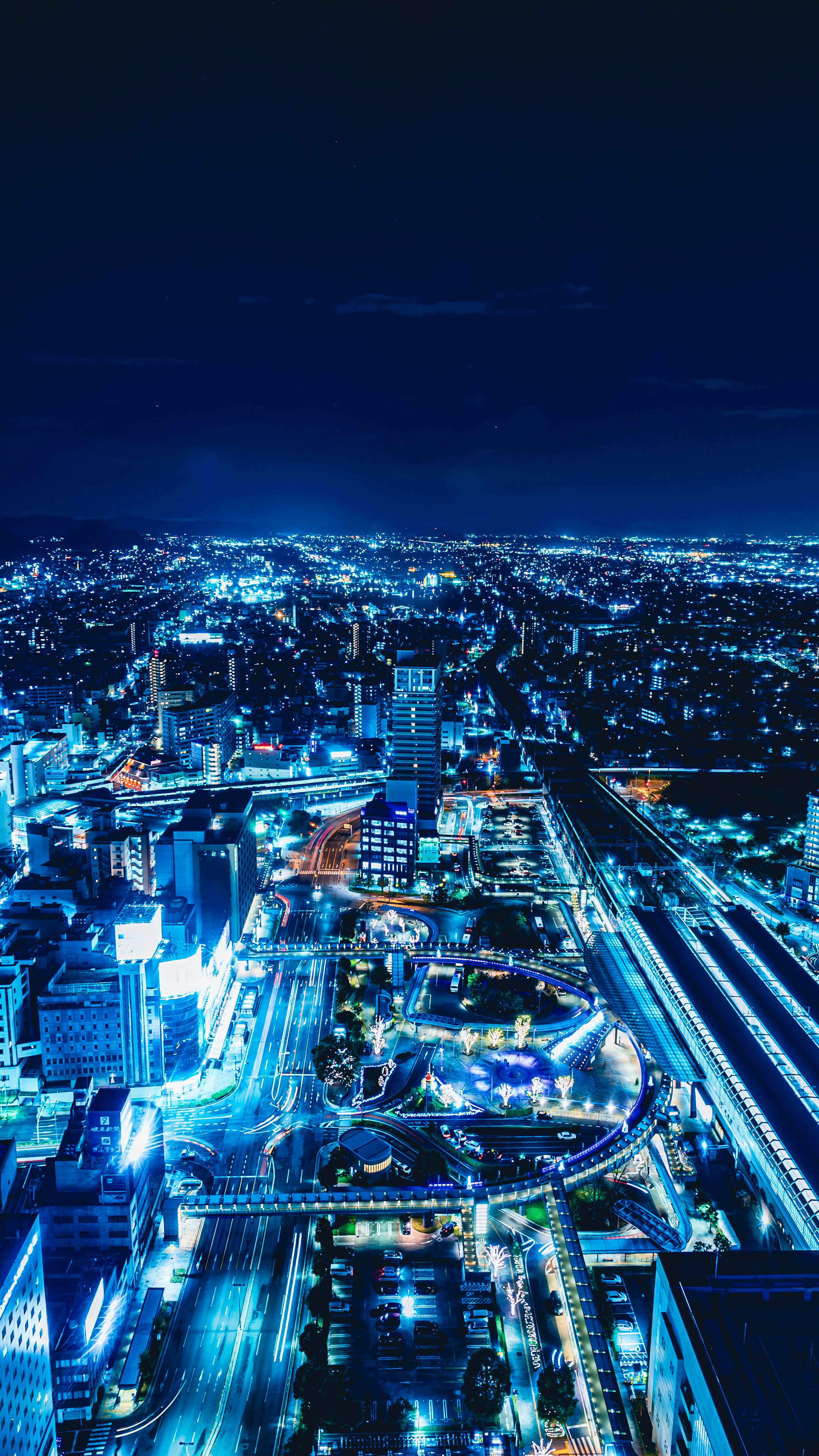 Paisaje urbano nocturno con rascacielos iluminados y carreteras