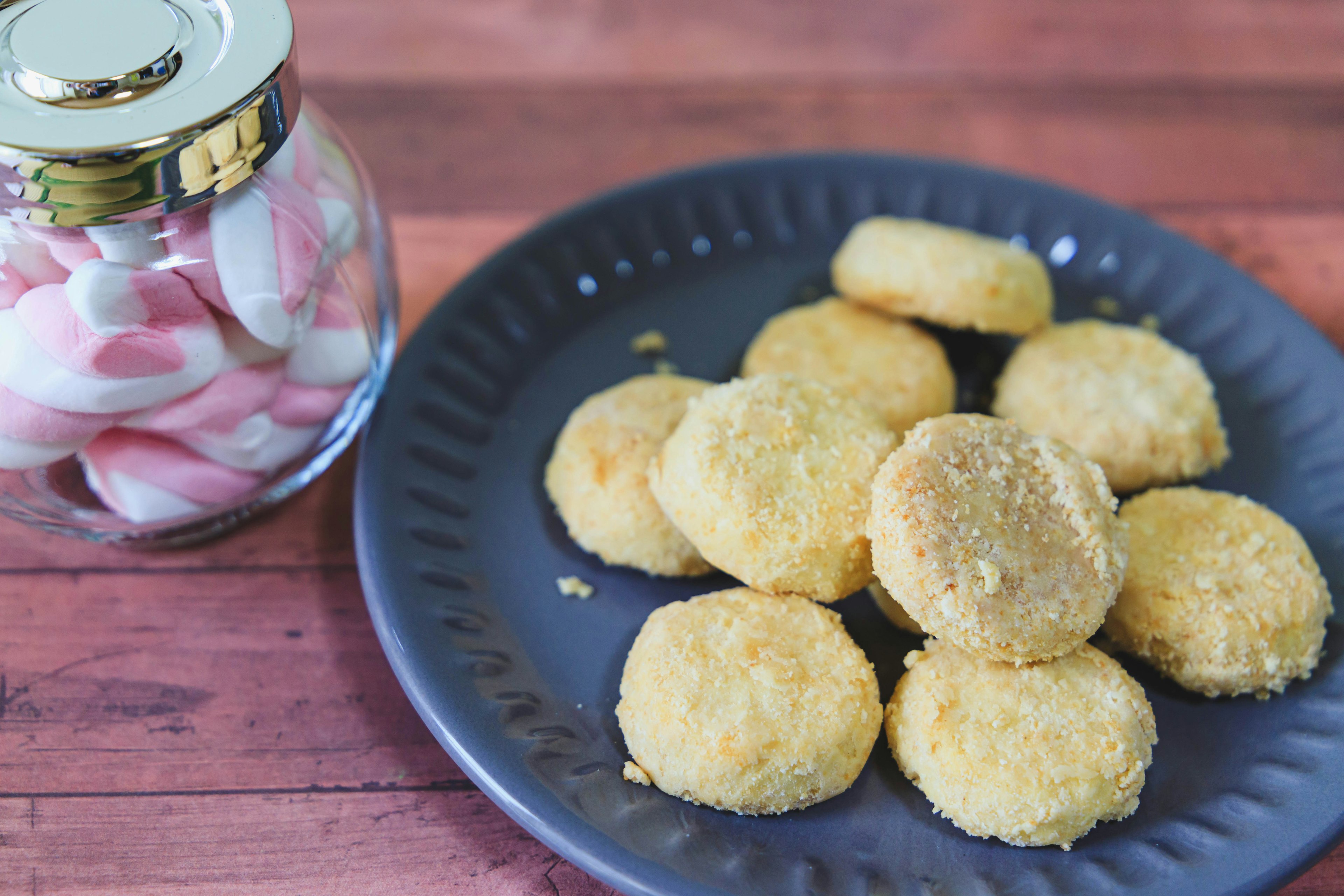 Kue yang disusun di piring dengan toples permen di sampingnya