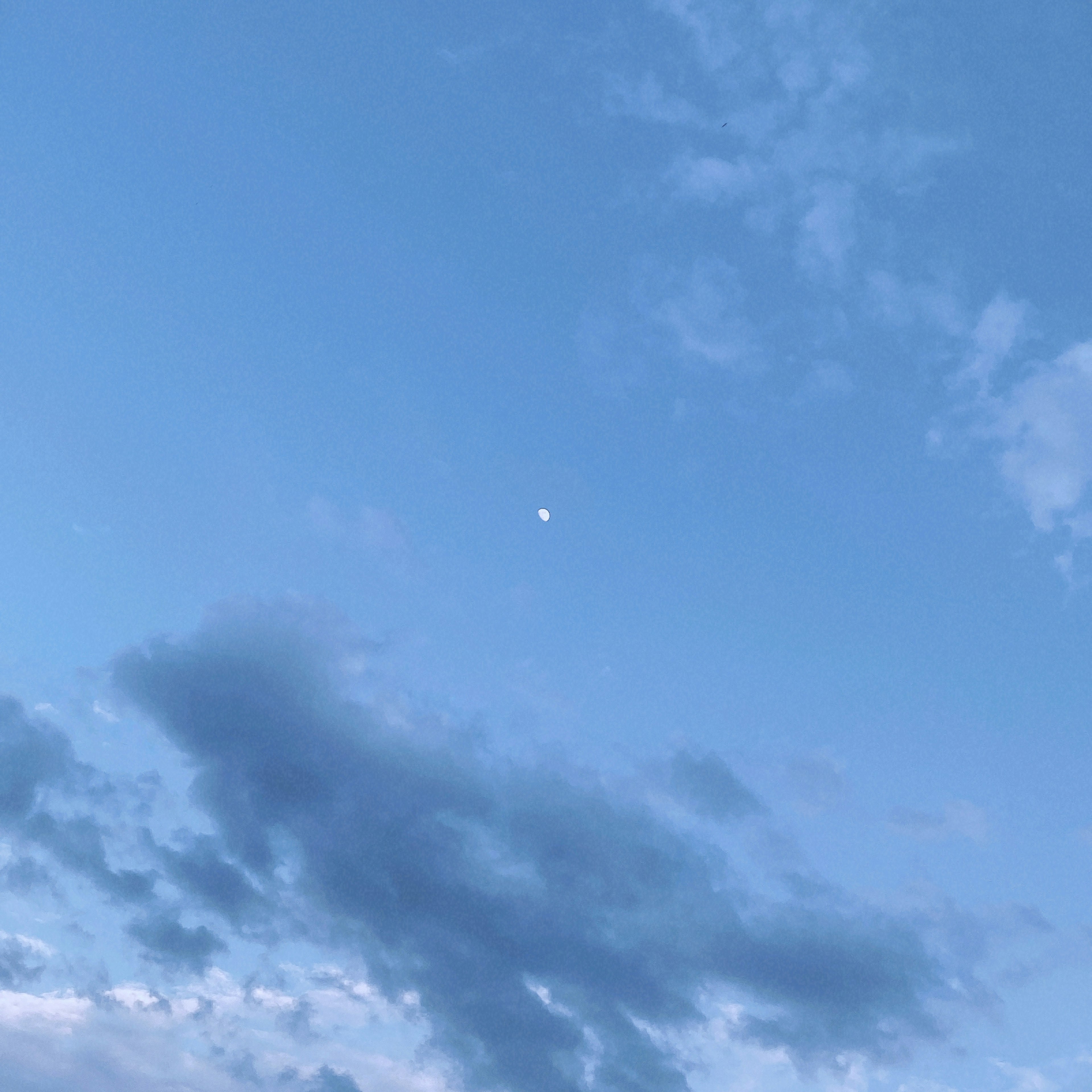 Nubes y luna en un cielo azul