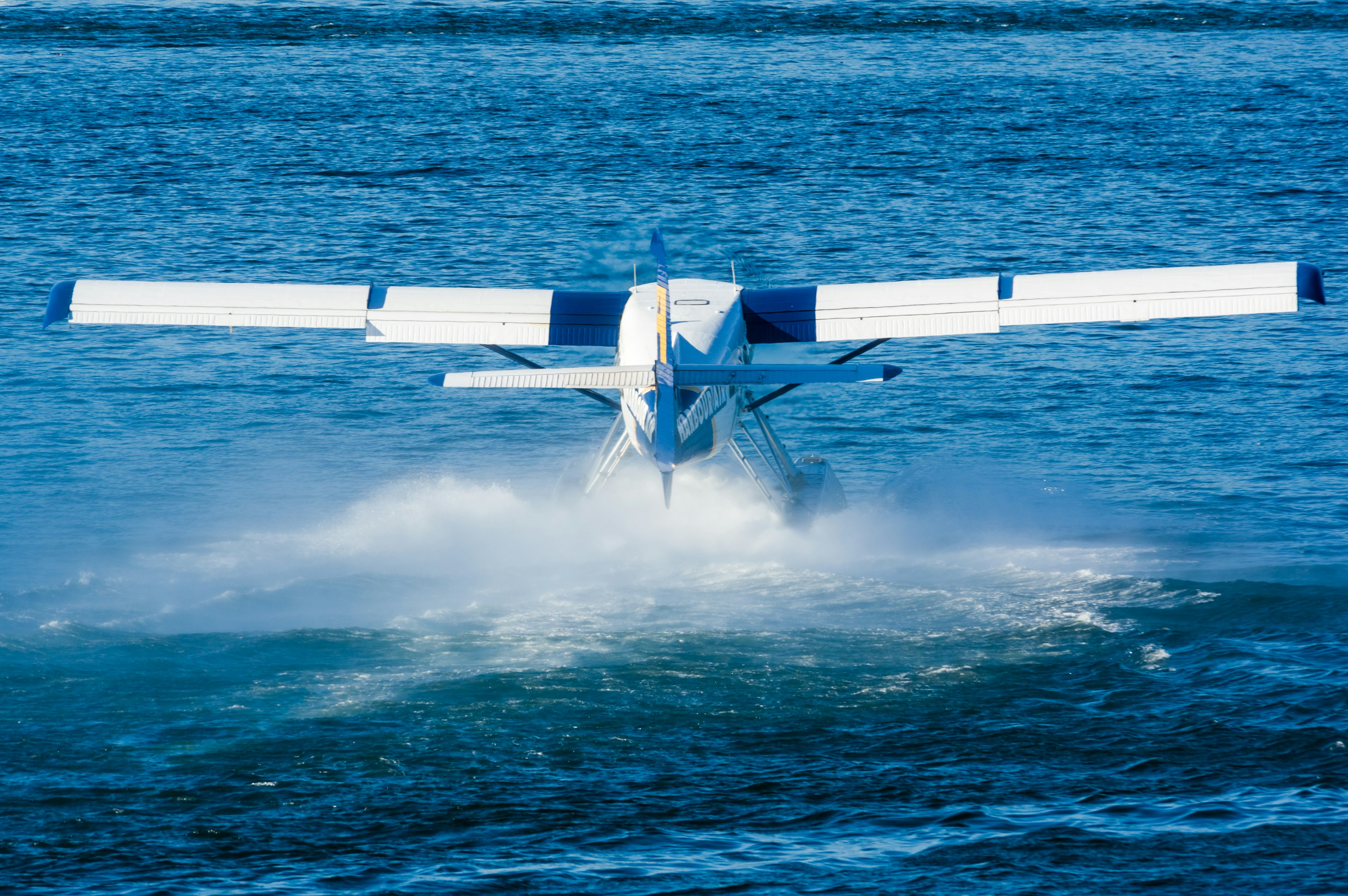 水上を離陸する水上飛行機の後ろ姿