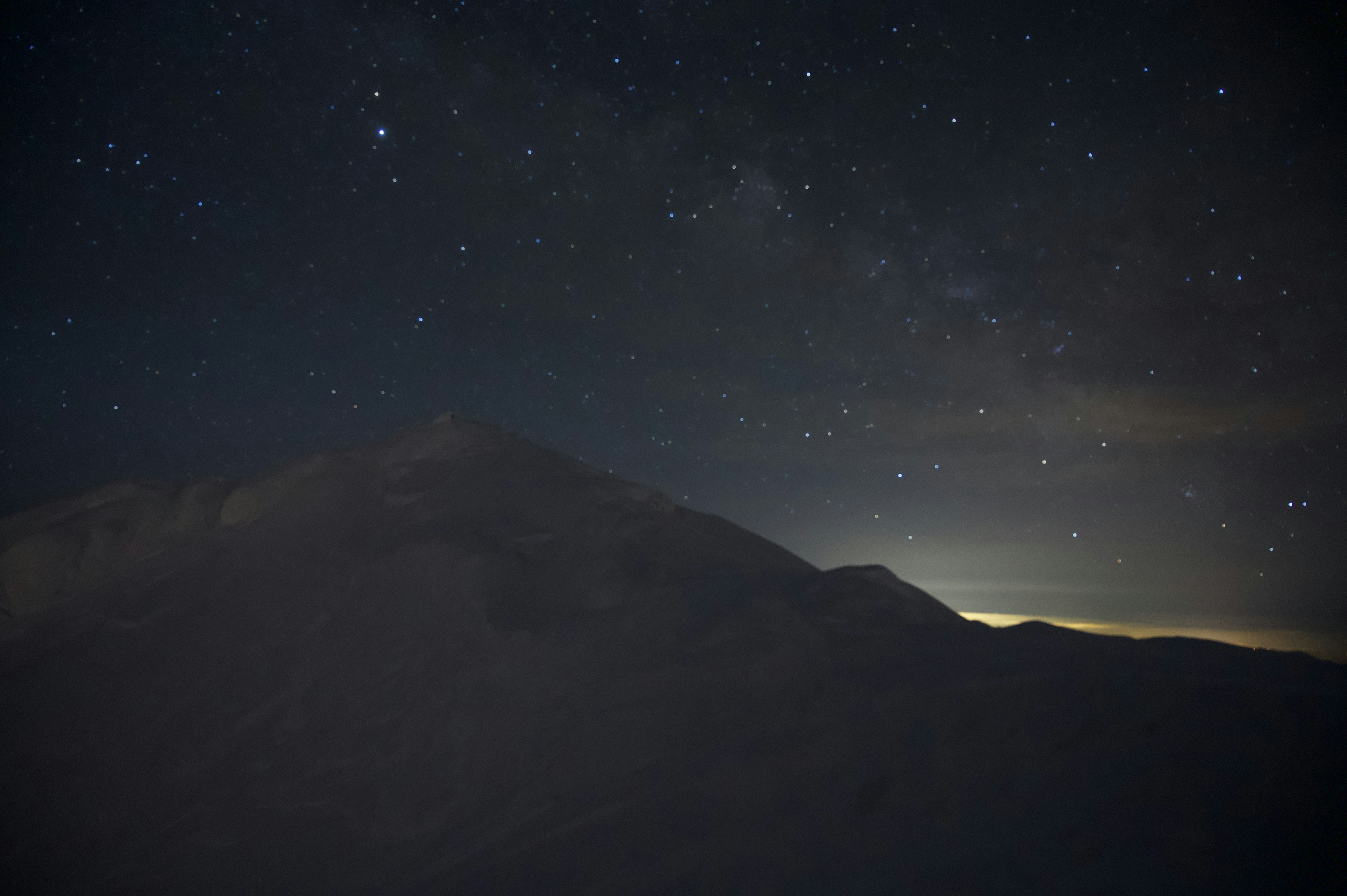 夜空に広がる星々と山のシルエット