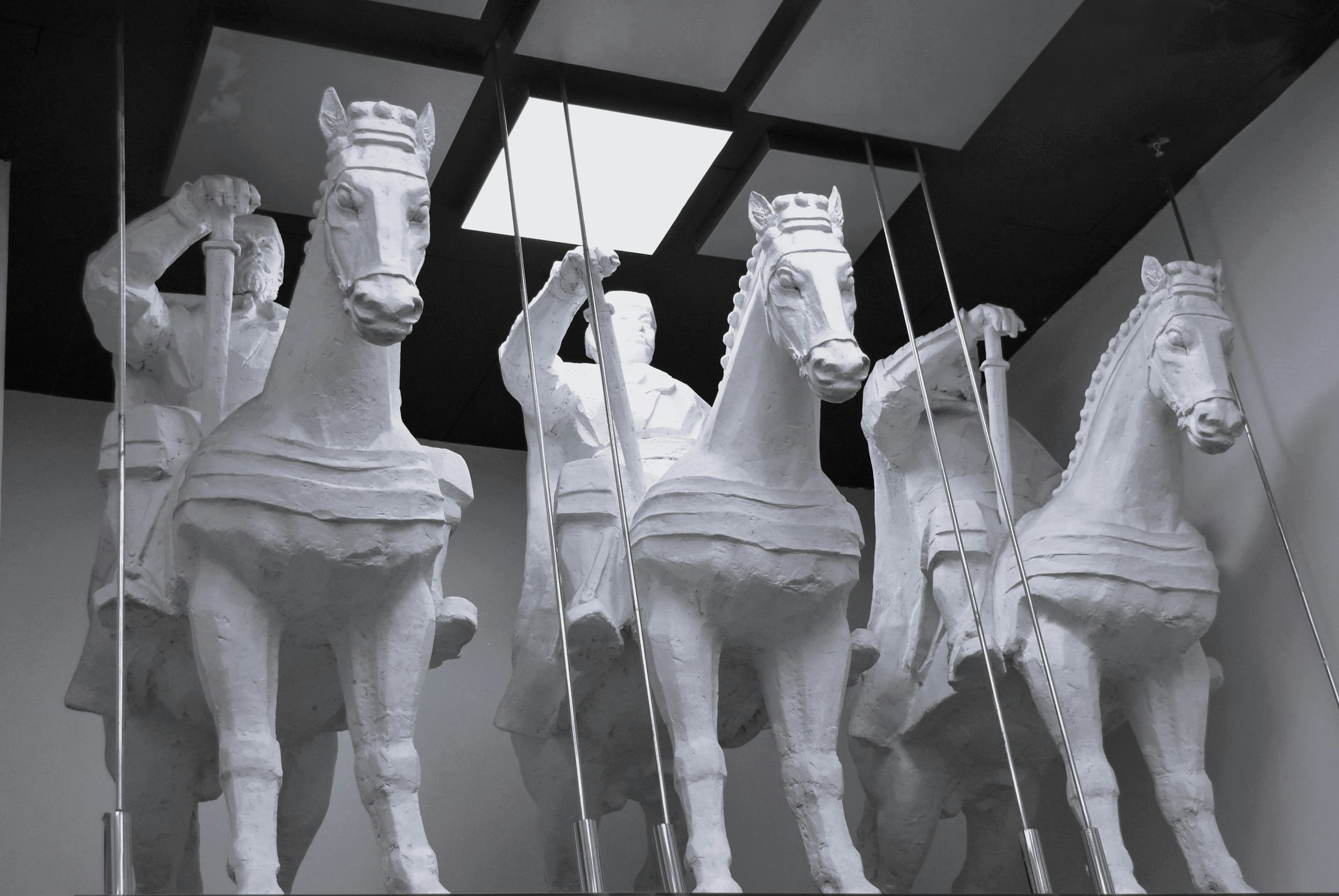 Interior of an exhibition featuring white horse and rider sculptures