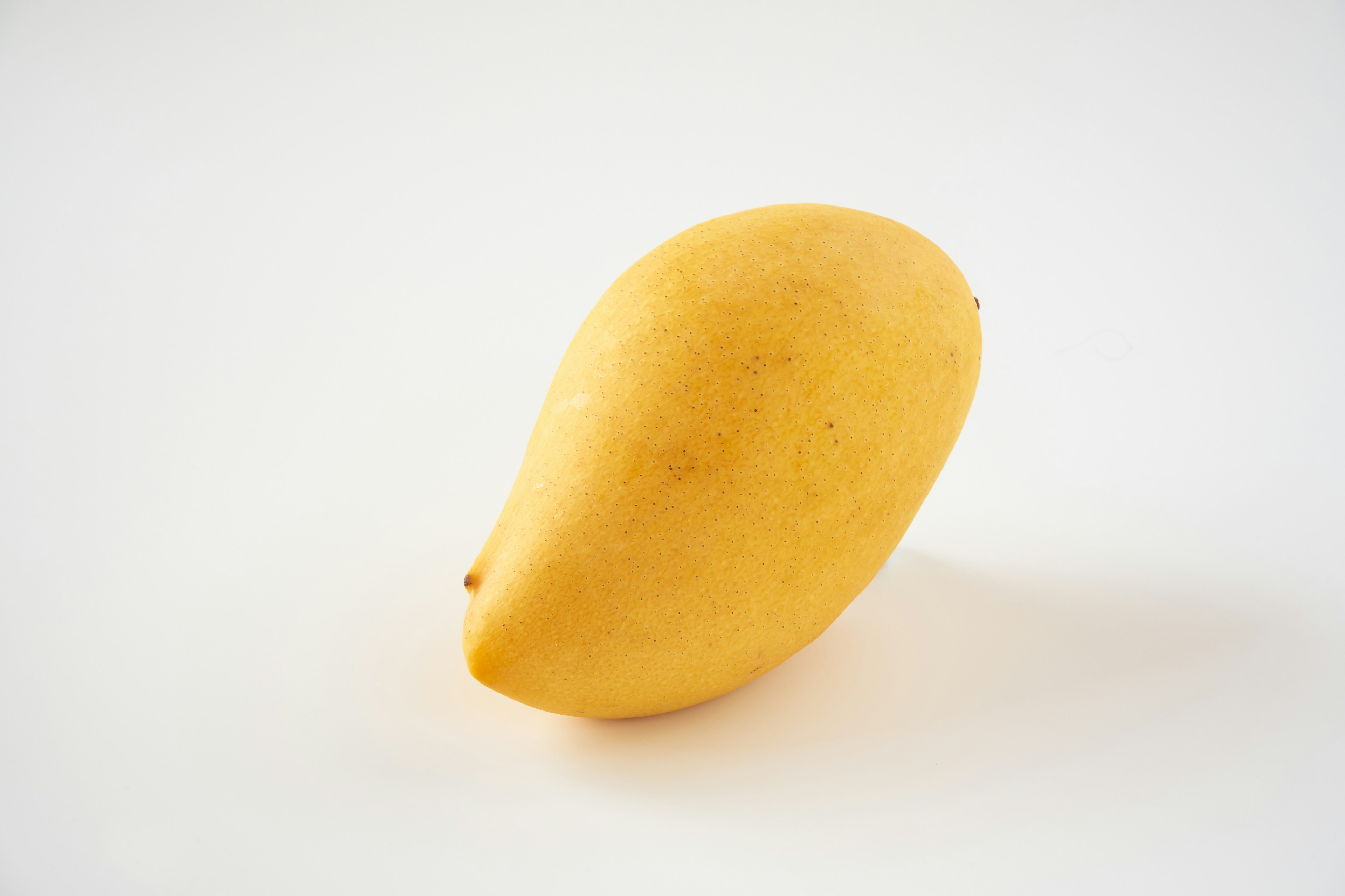 Eine gelbe Mango auf einem weißen Hintergrund