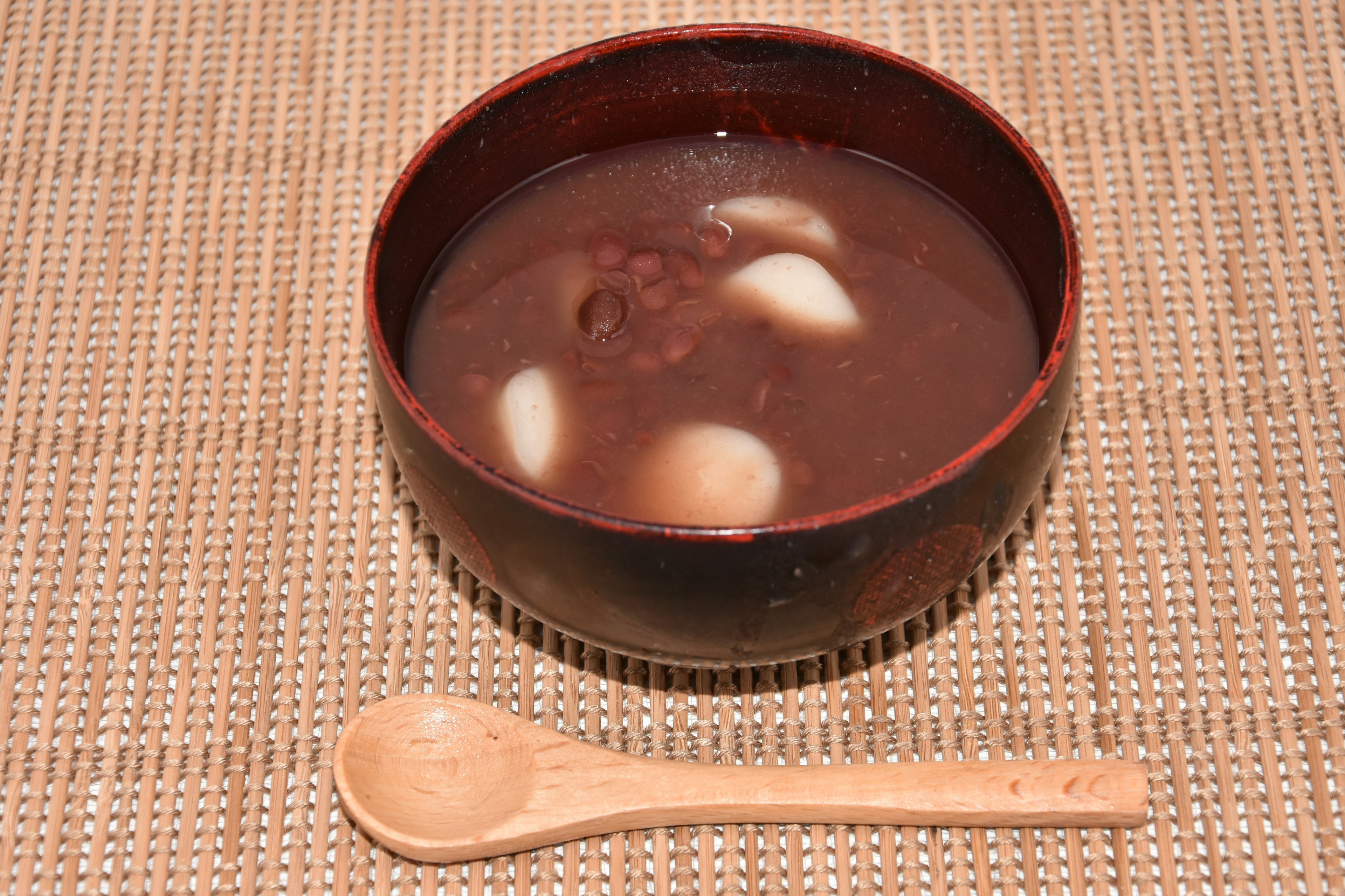 Sweet red bean soup with white dumplings in a red bowl