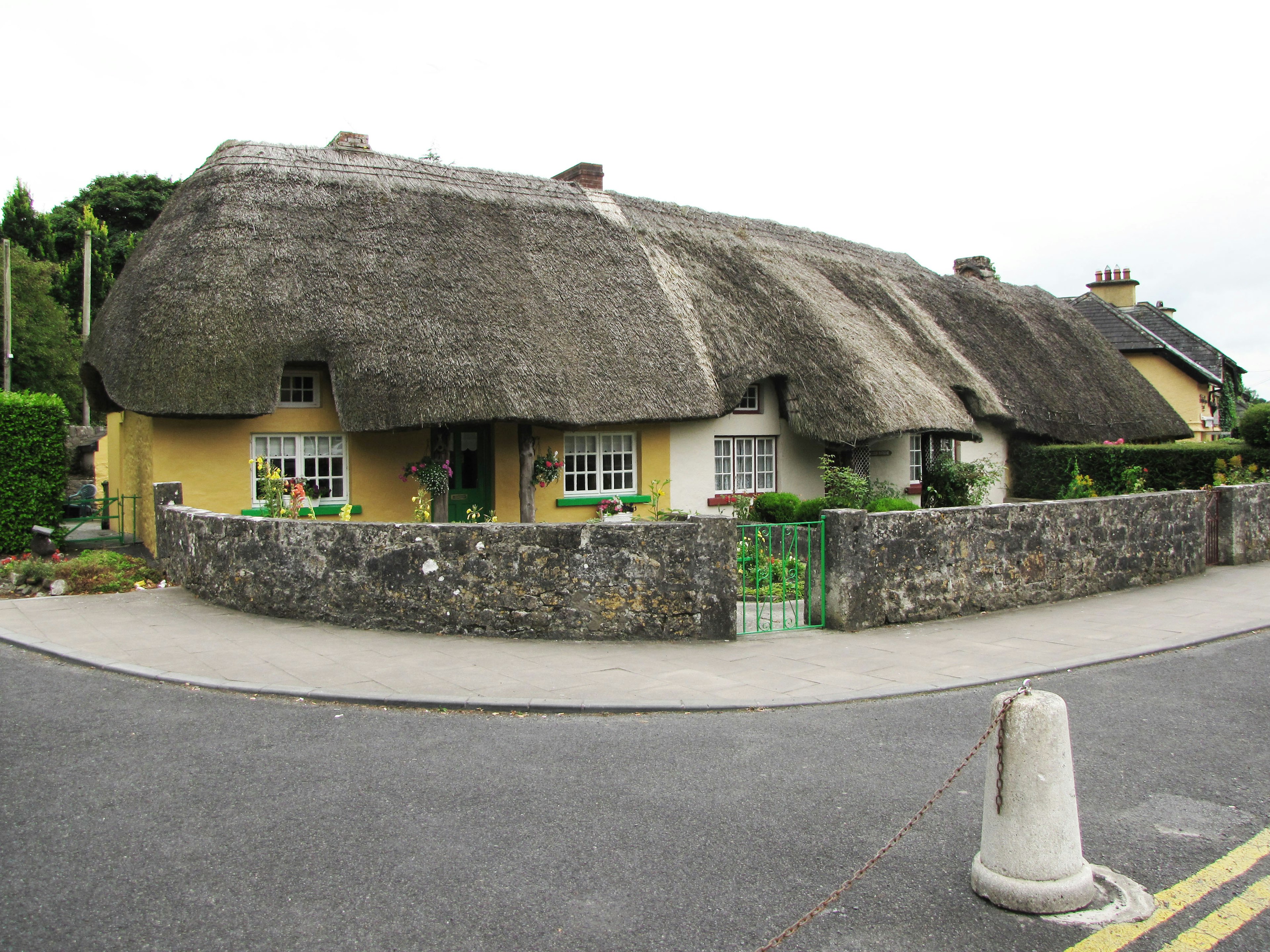 Cottage tradizionale con tetto di paglia e muro in pietra