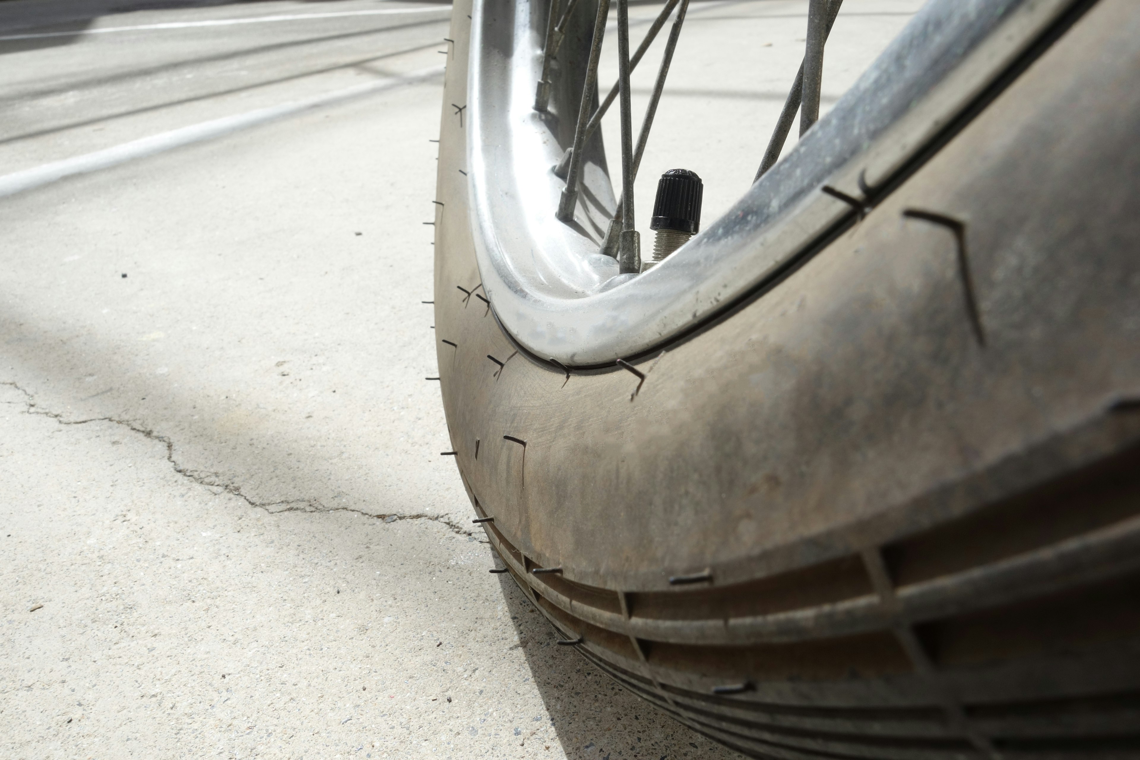 Nahaufnahme eines Fahrradreifens mit rissiger Oberfläche und glänzendem Felge