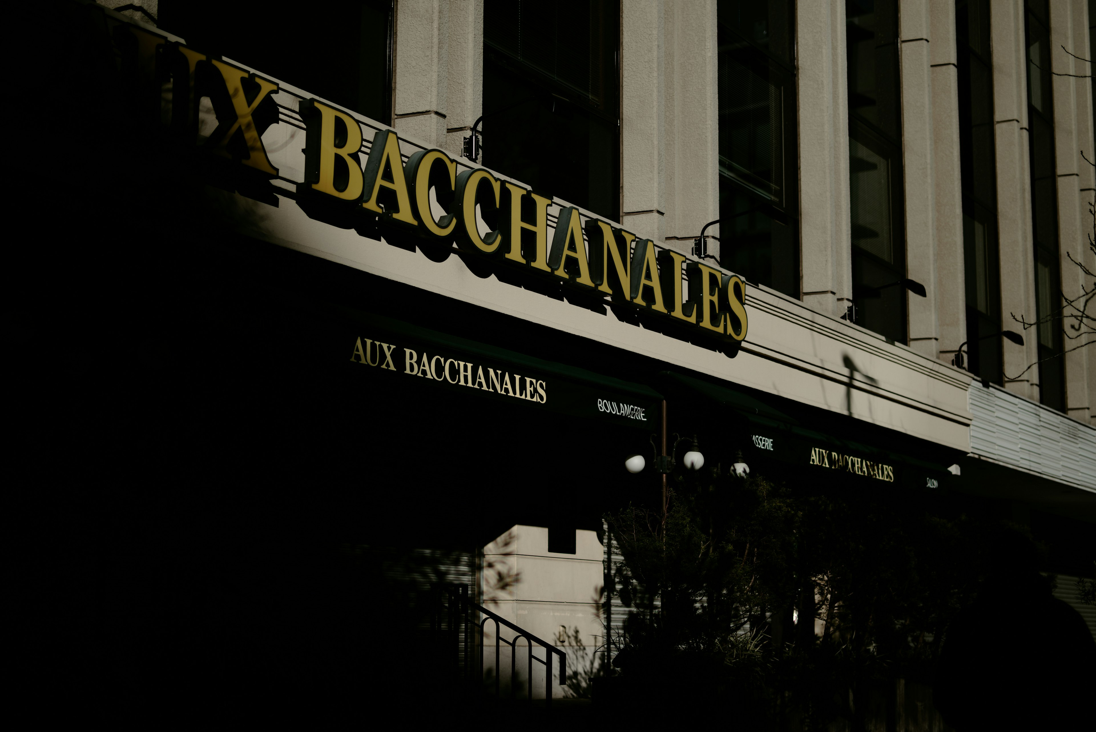 ภาพกลางคืนของภายนอกที่มีป้าย Bacchanales