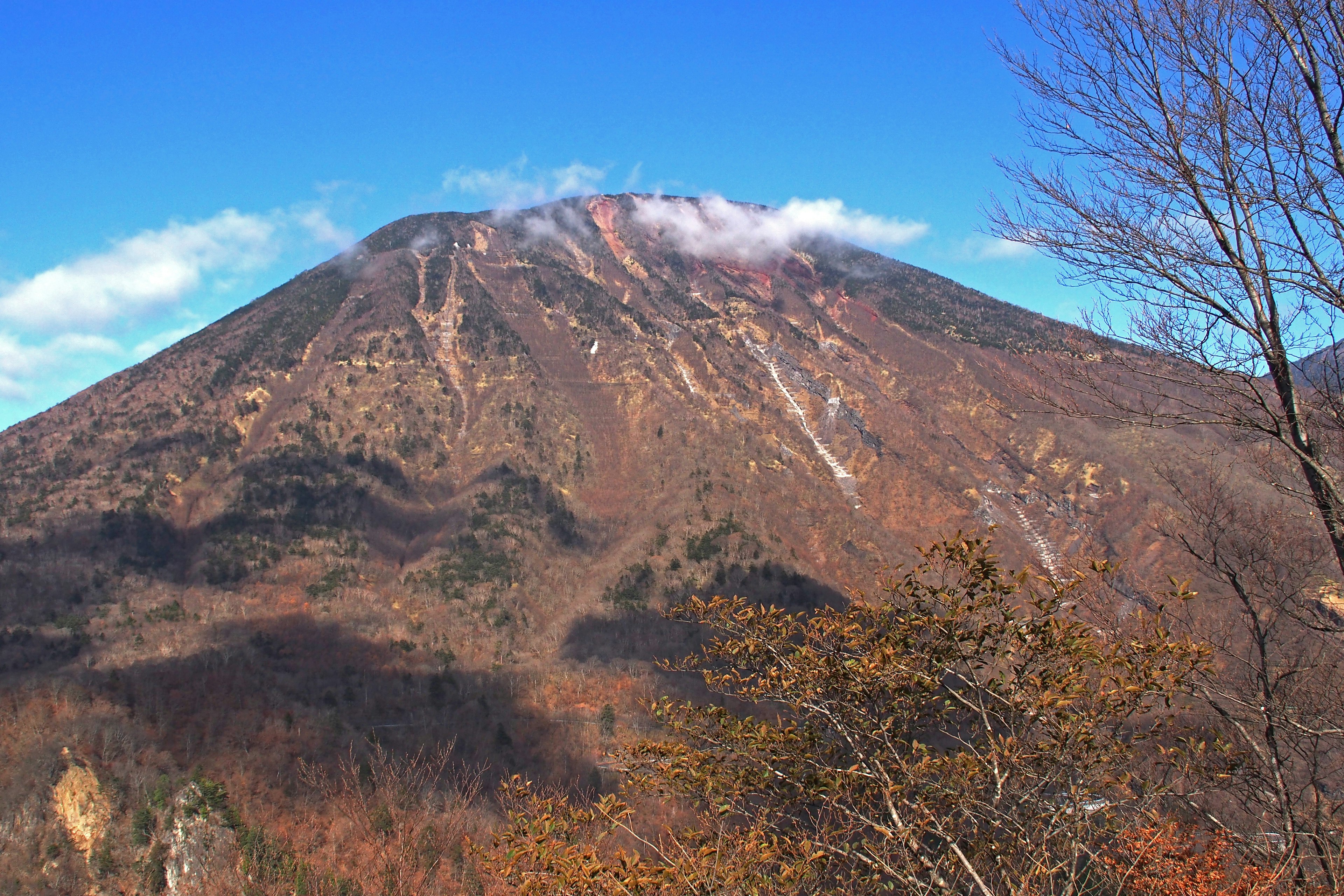 Pemandangan gunung yang indah dengan langit biru dan awan menampilkan warna musim gugur