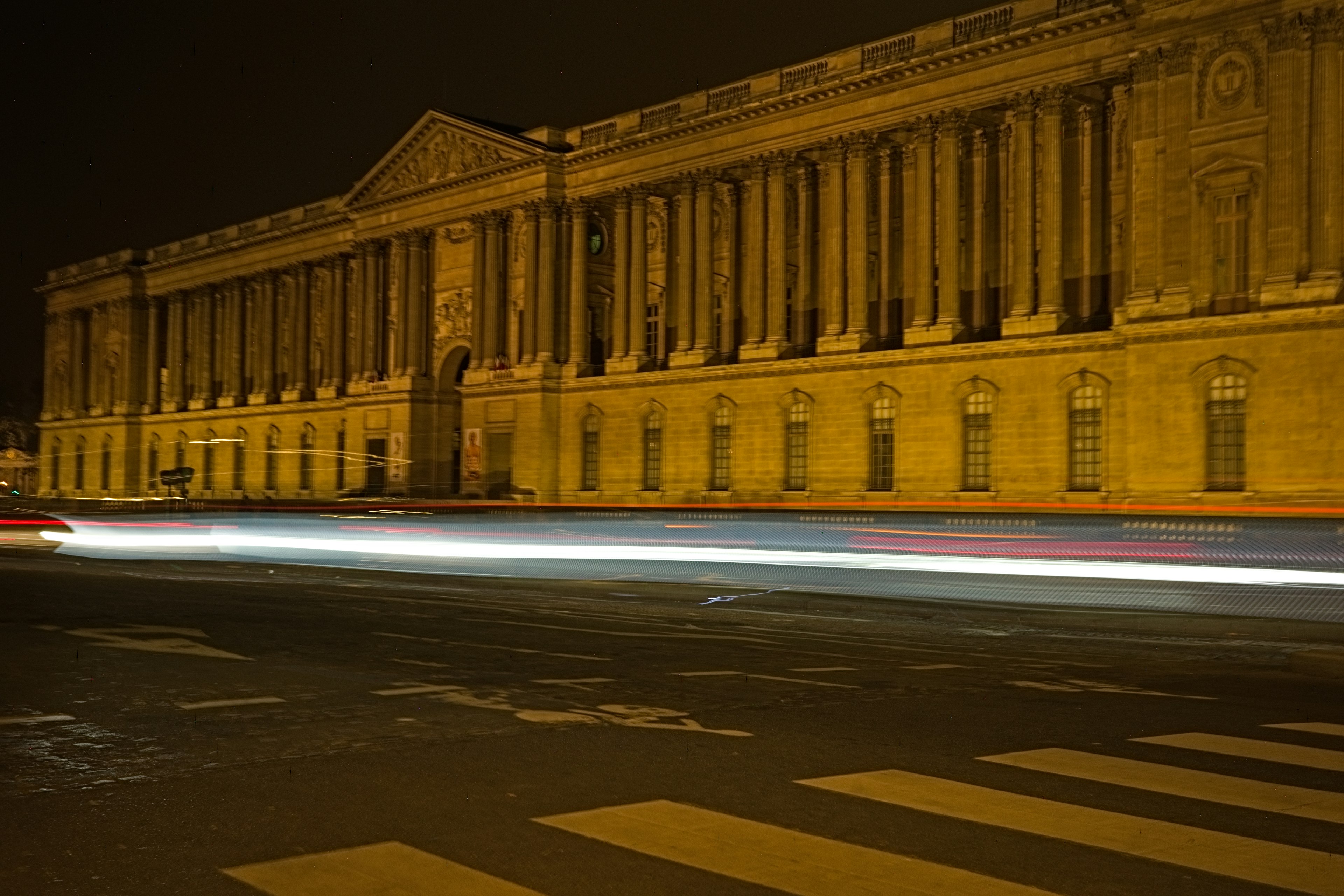 Historisches Gebäude bei Nacht beleuchtet mit Lichtspuren von vorbeifahrenden Autos