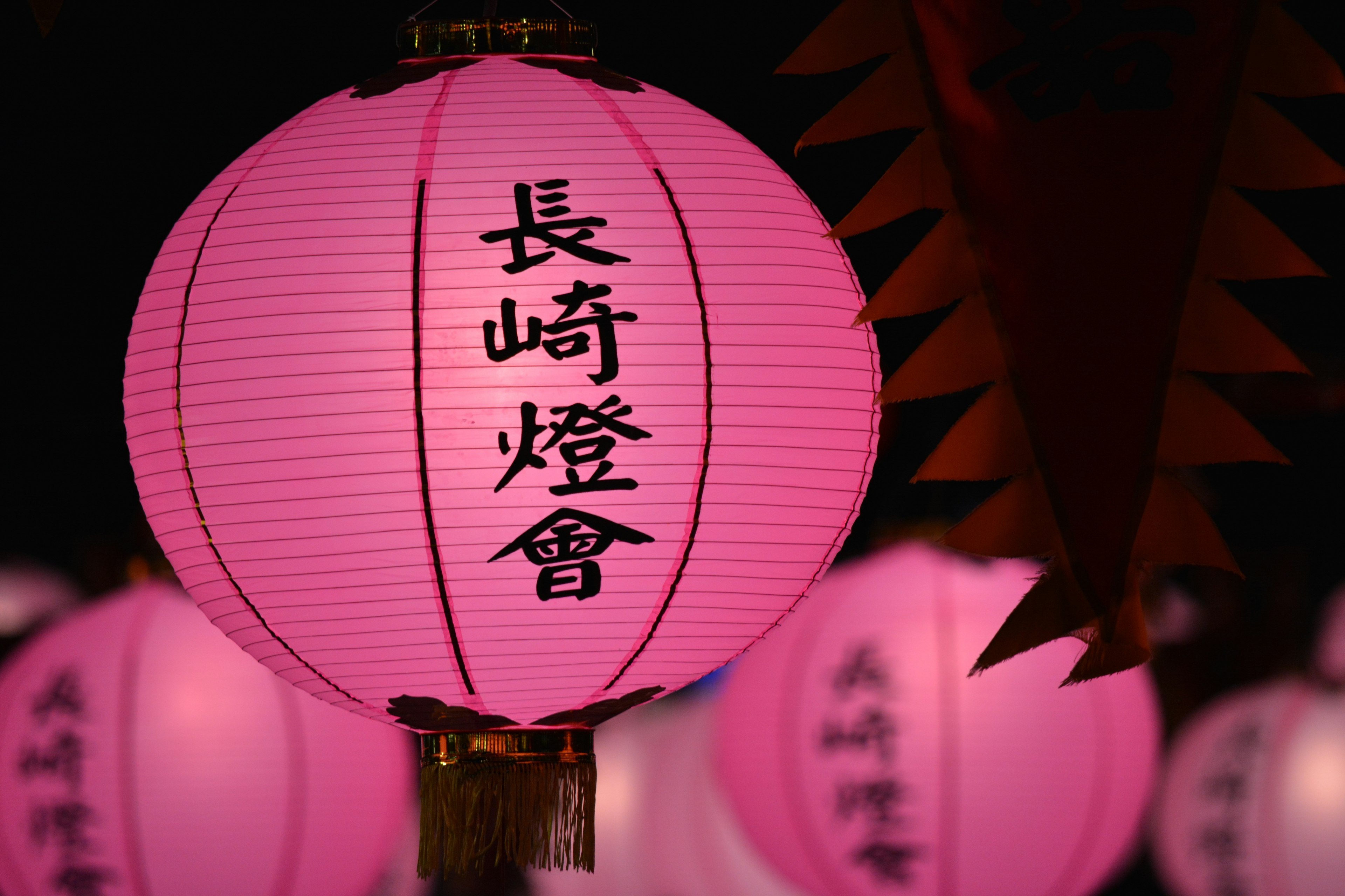 Lámpara rosa con el texto Asociación de Linternas de Nagasaki