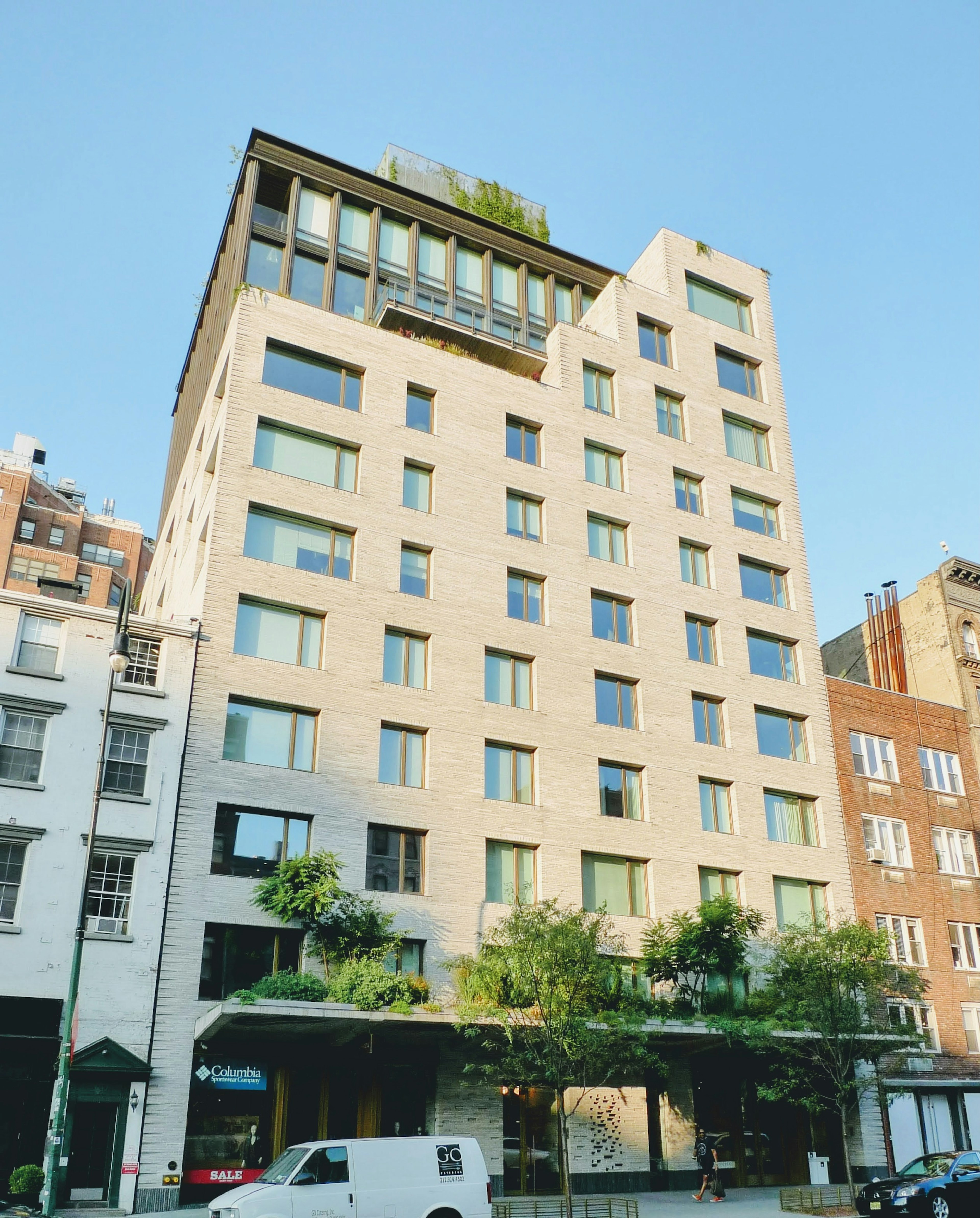 Fachada moderna de un edificio con jardín en la azotea verde