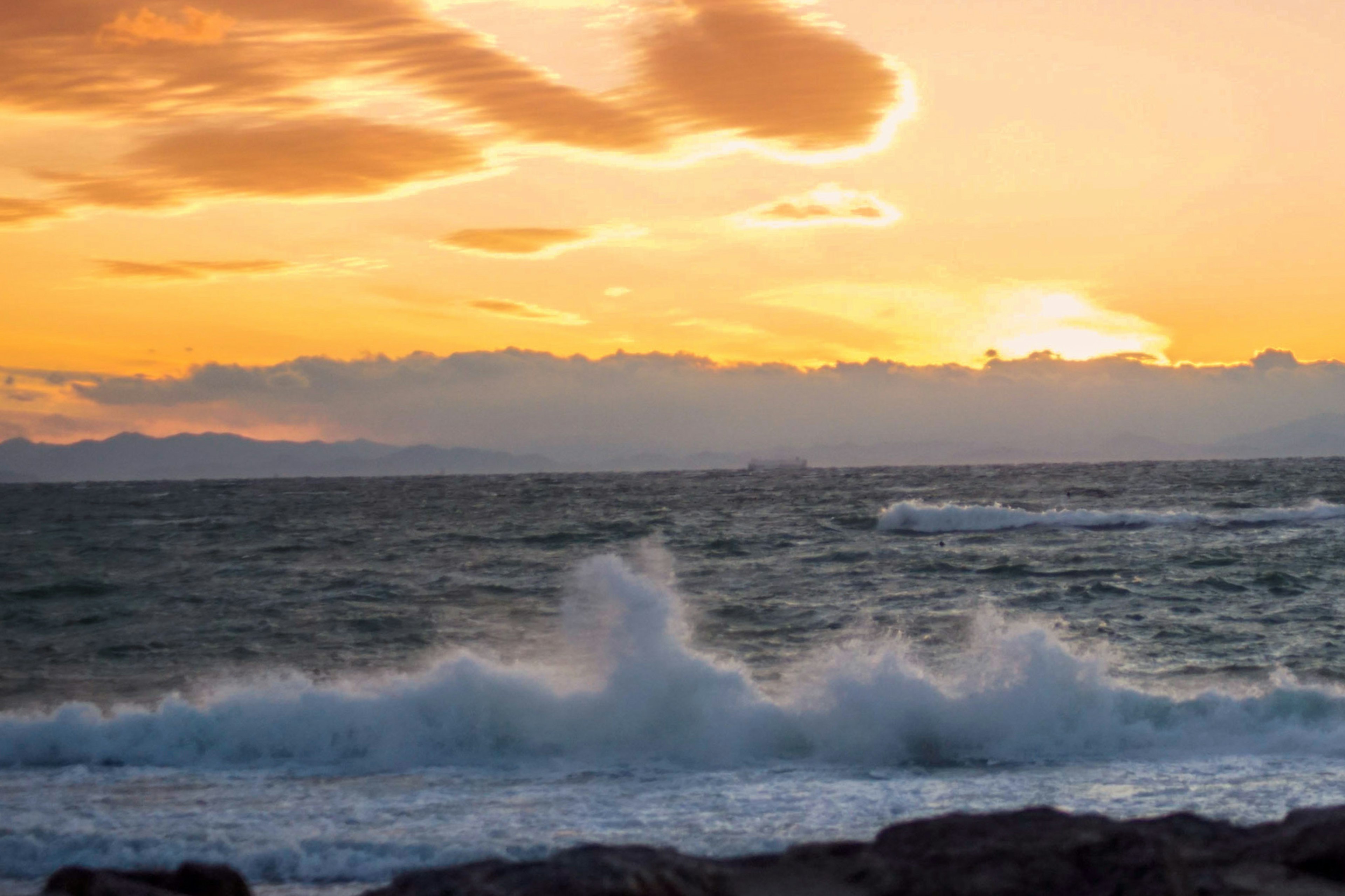 夕日が沈む海の波と雲の美しい景色