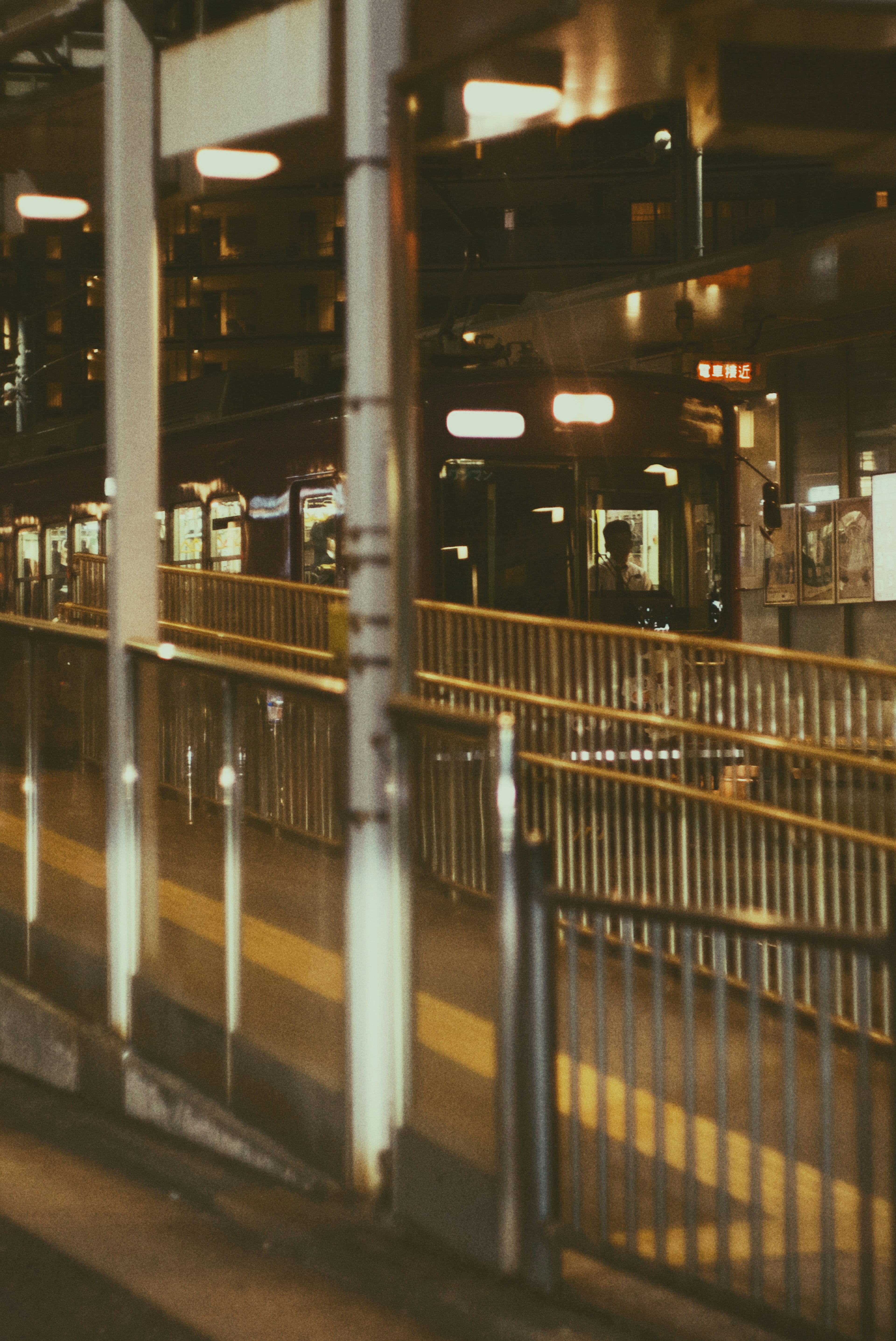 Escena nocturna de una estación de tren con andén y señales