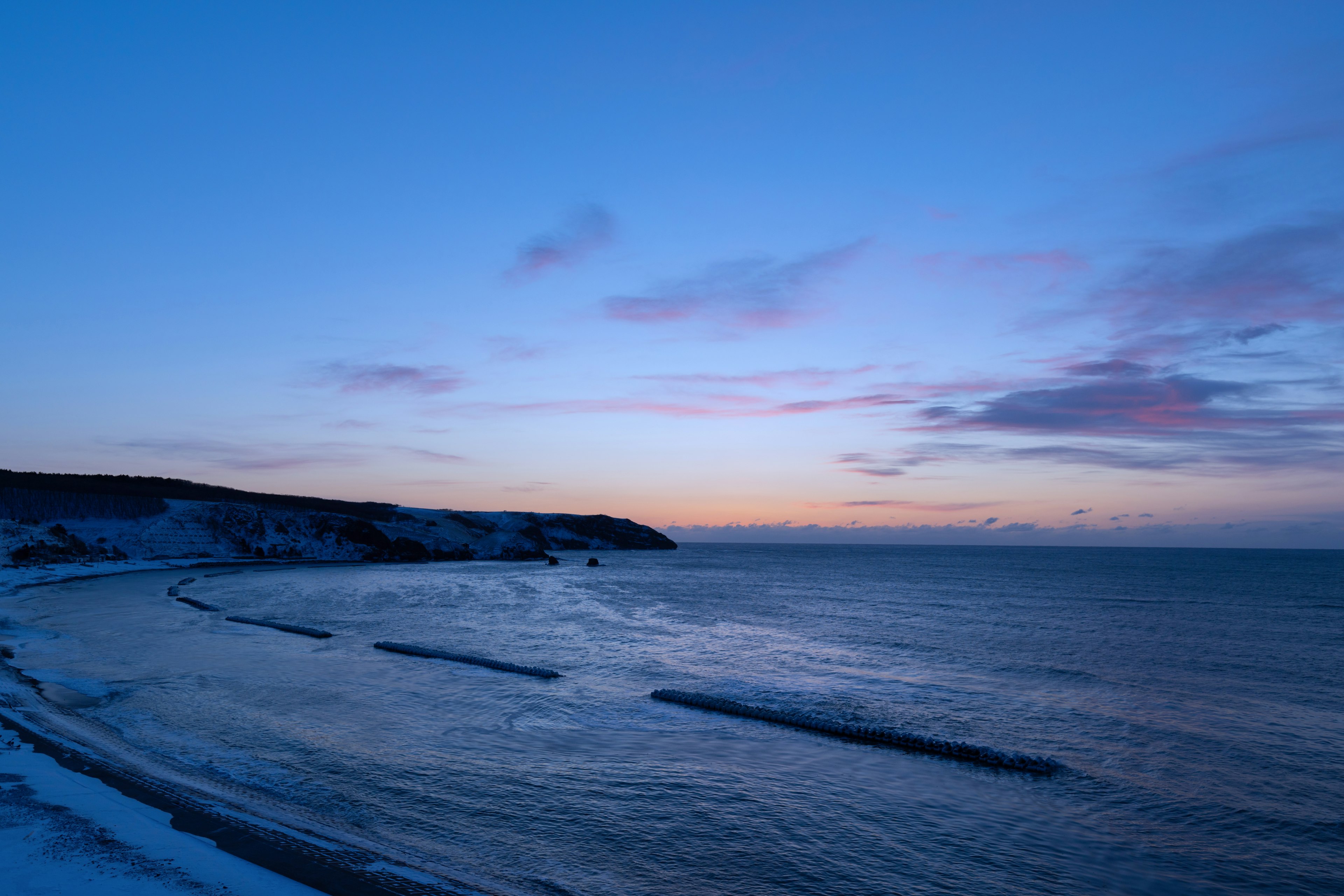 Twilight shoreline with calm waves and a serene sea