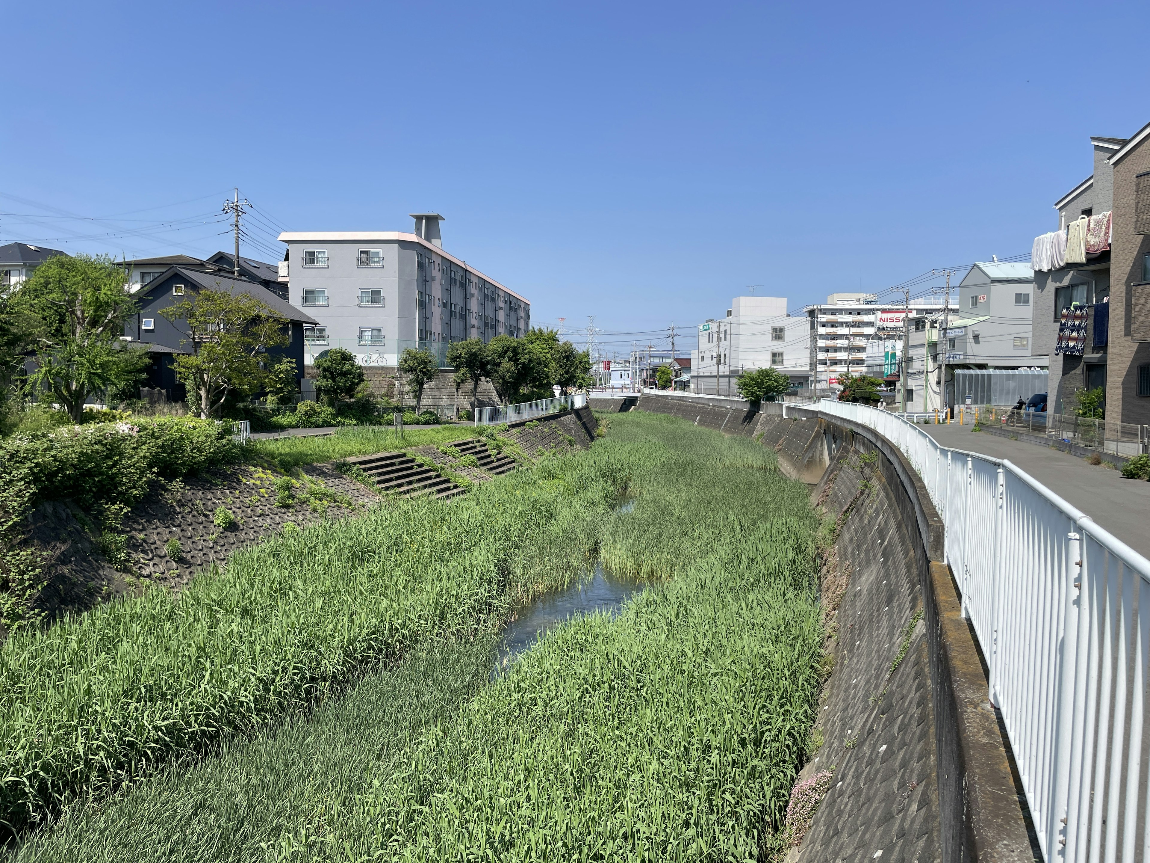 A calm river under a blue sky with surrounding buildings