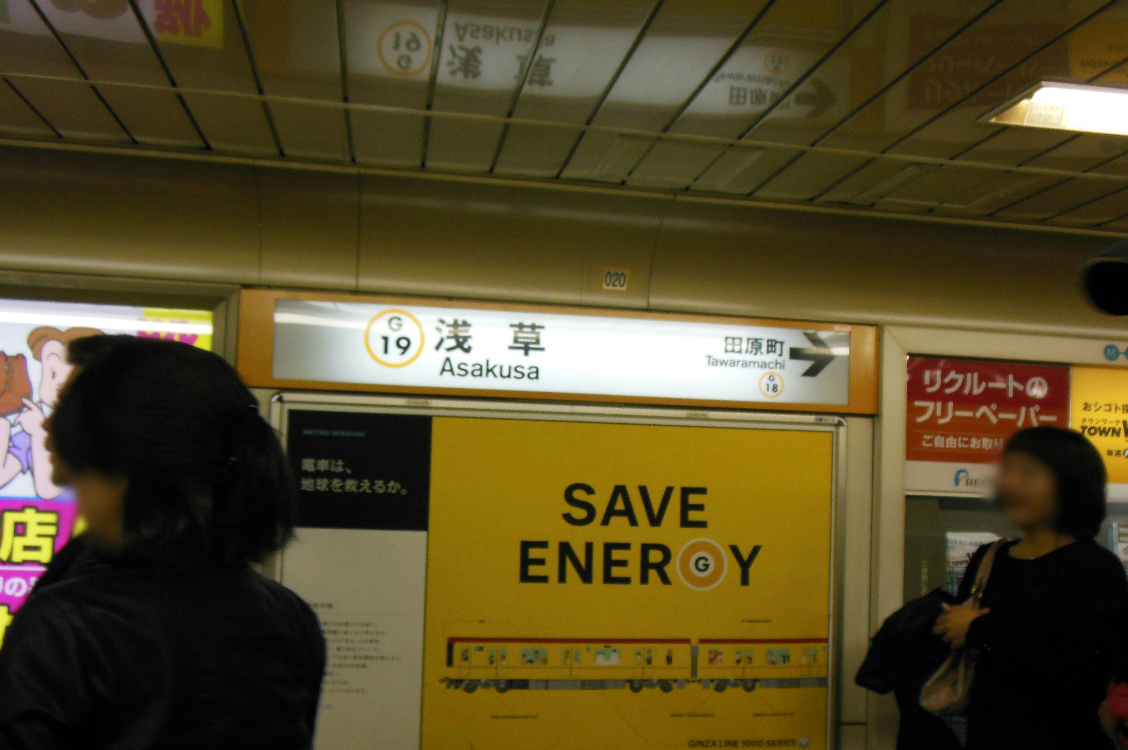 Señalización en la estación Asakusa con personas