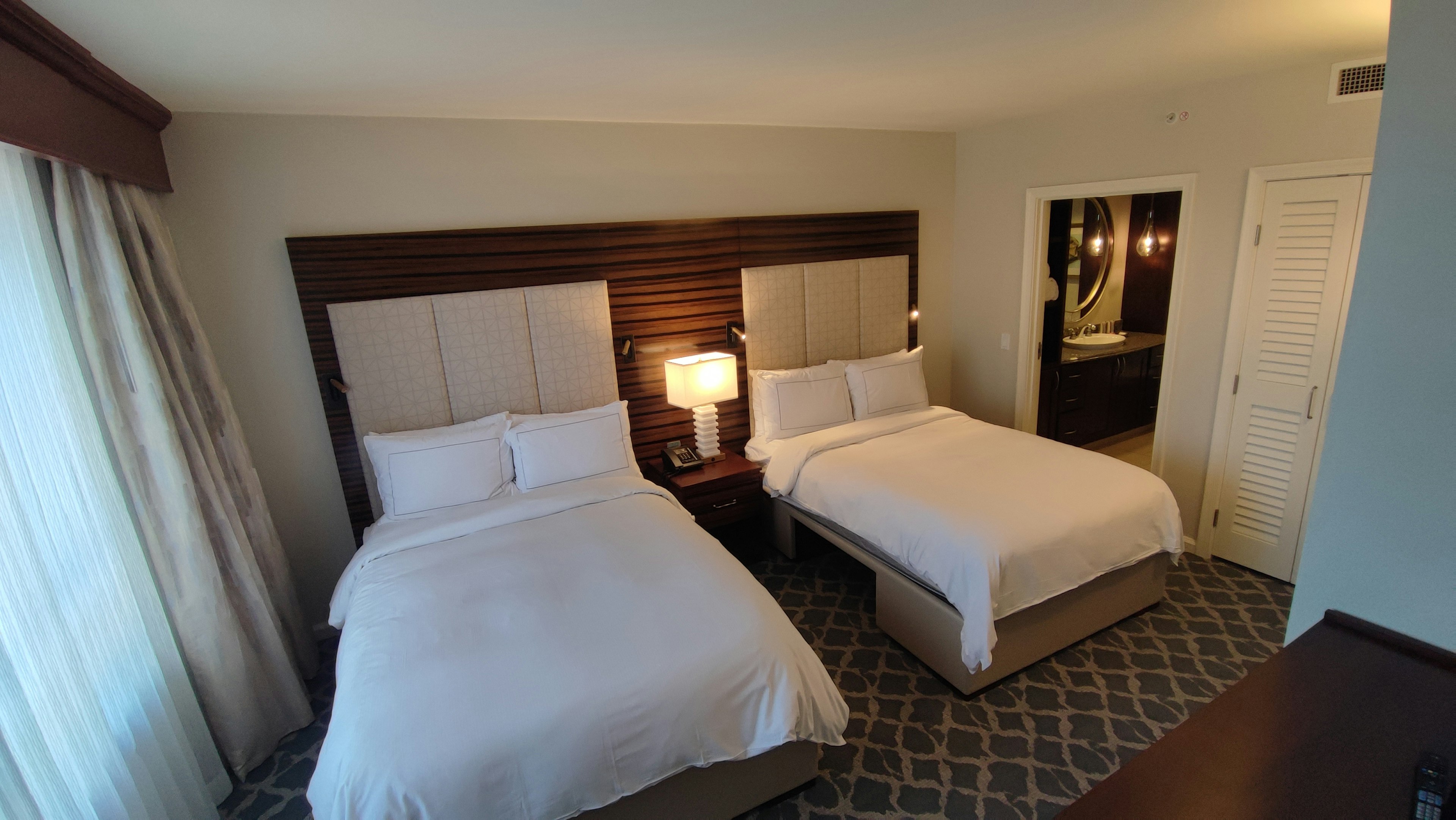 Bright twin bedroom featuring wooden headboards and natural light