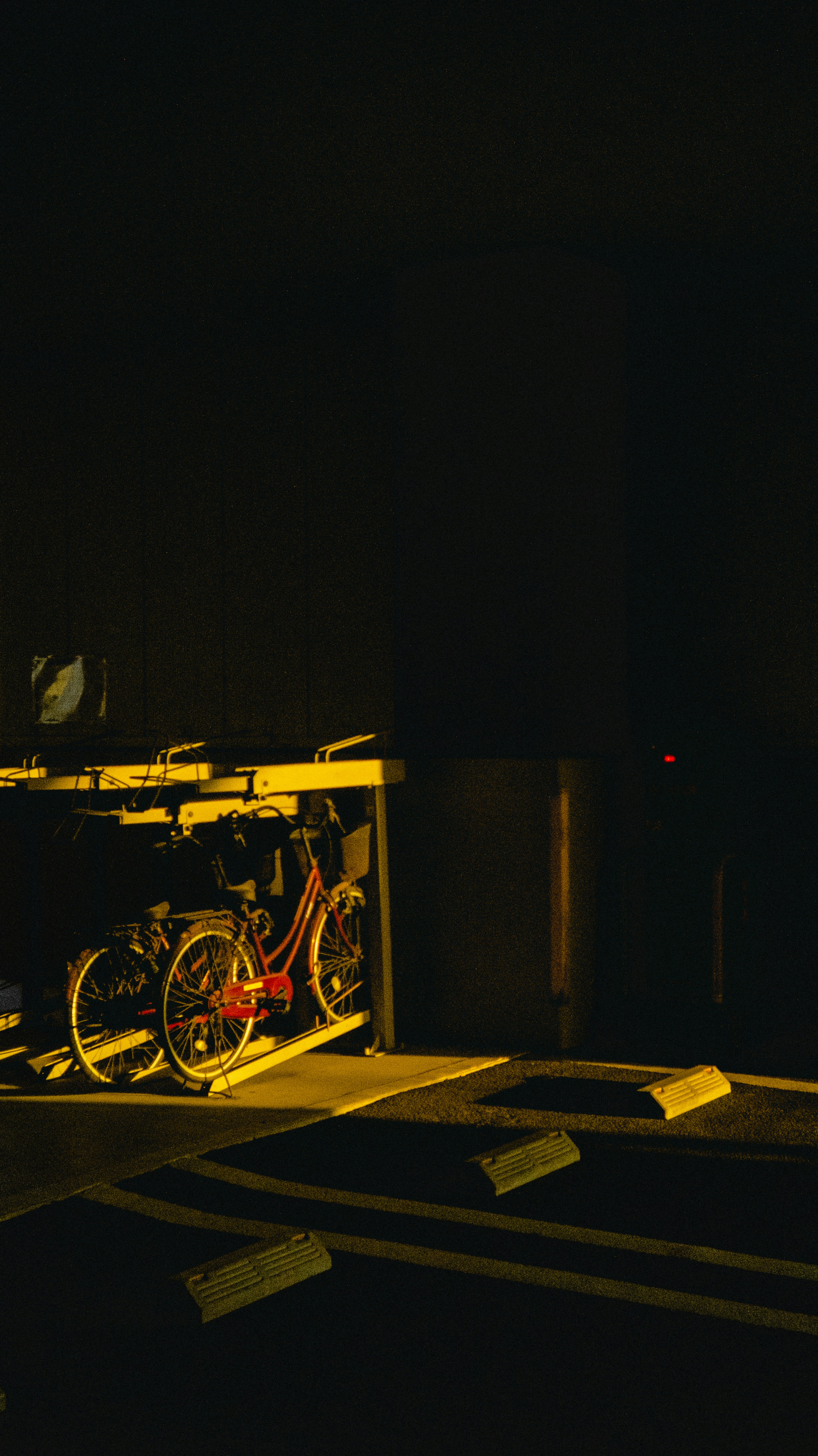 Bicycles in a dark setting illuminated by yellow light