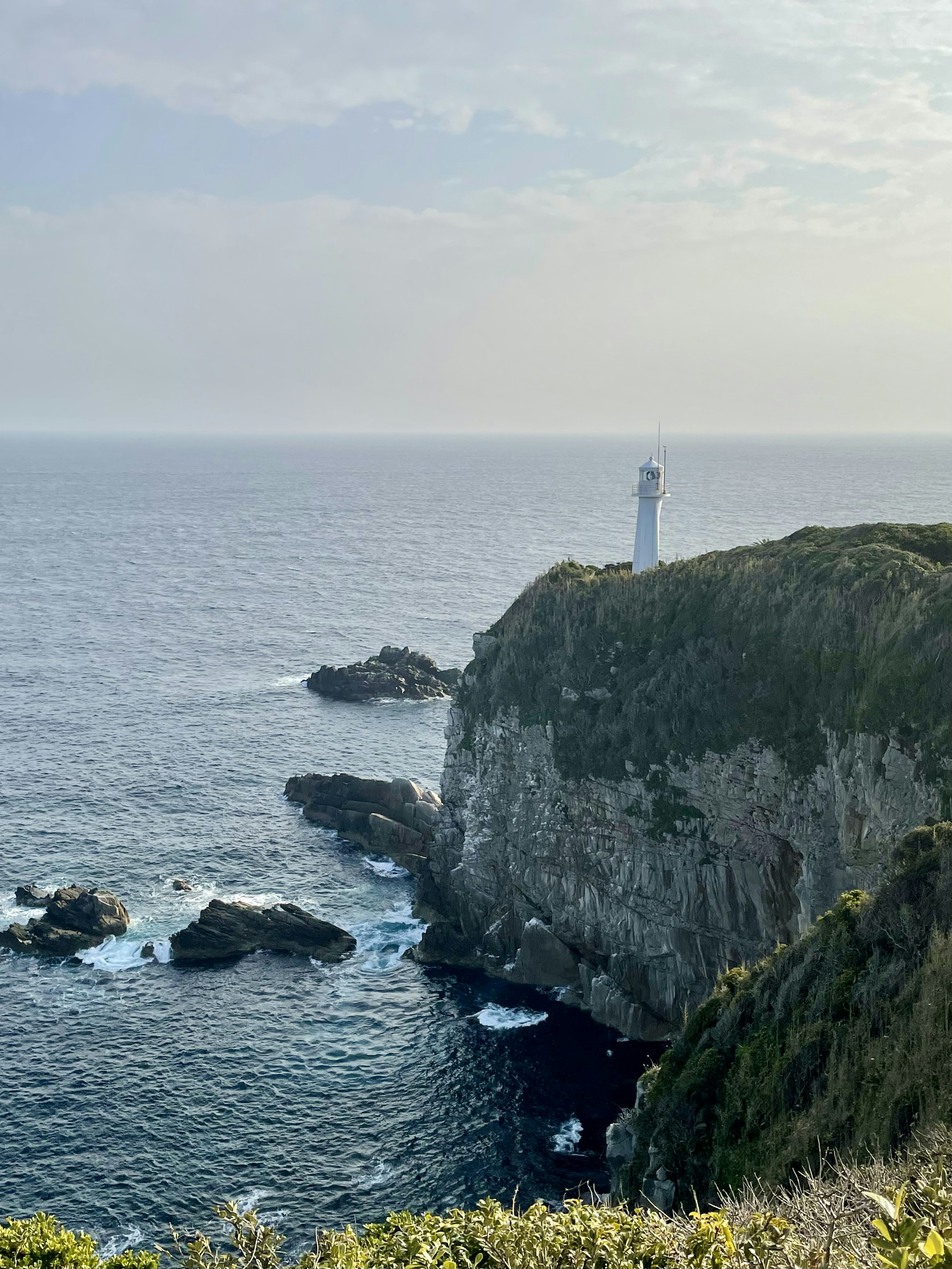 海に面した崖の上に立つ灯台の風景