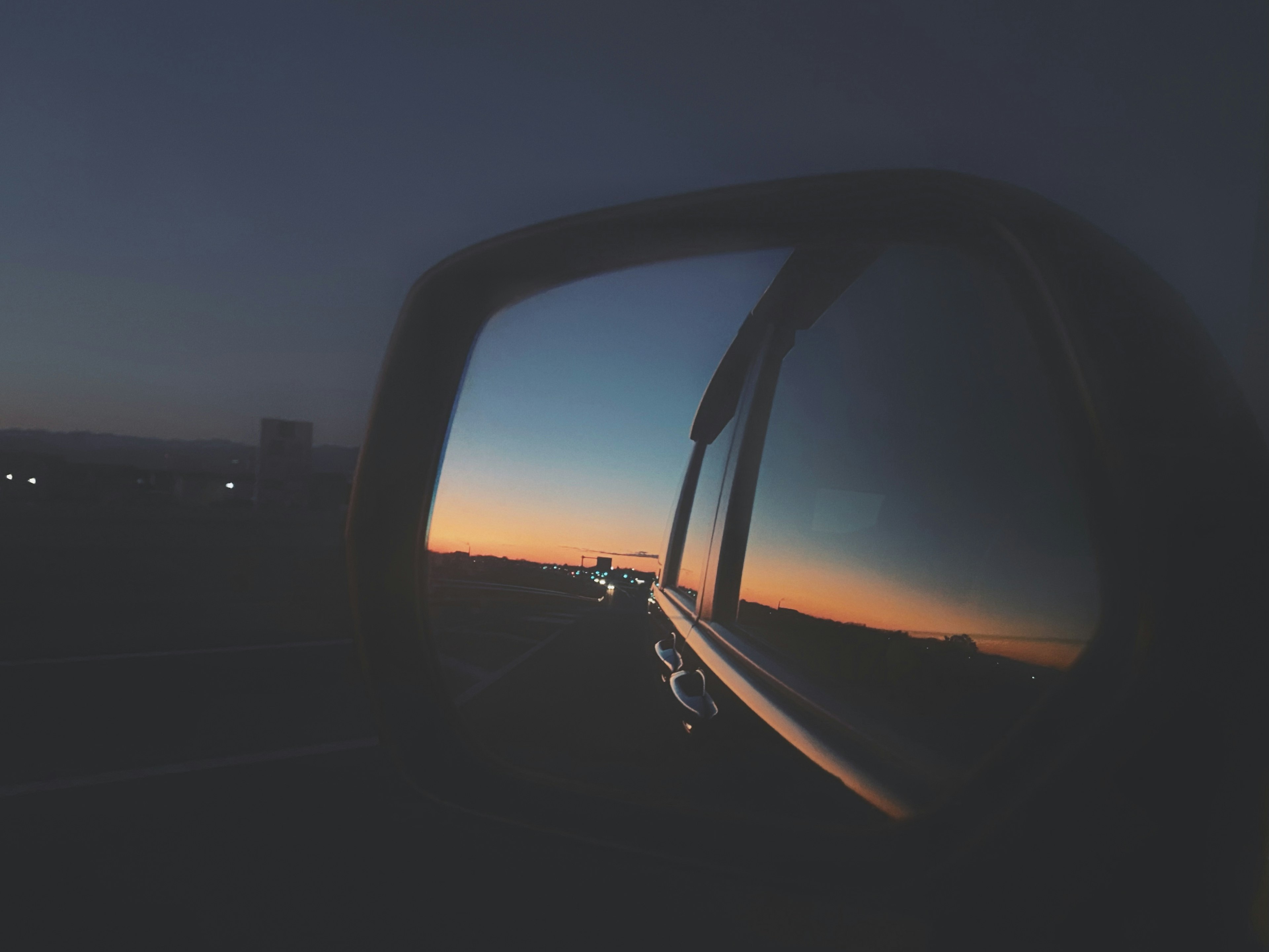 Sunset reflected in a car side mirror