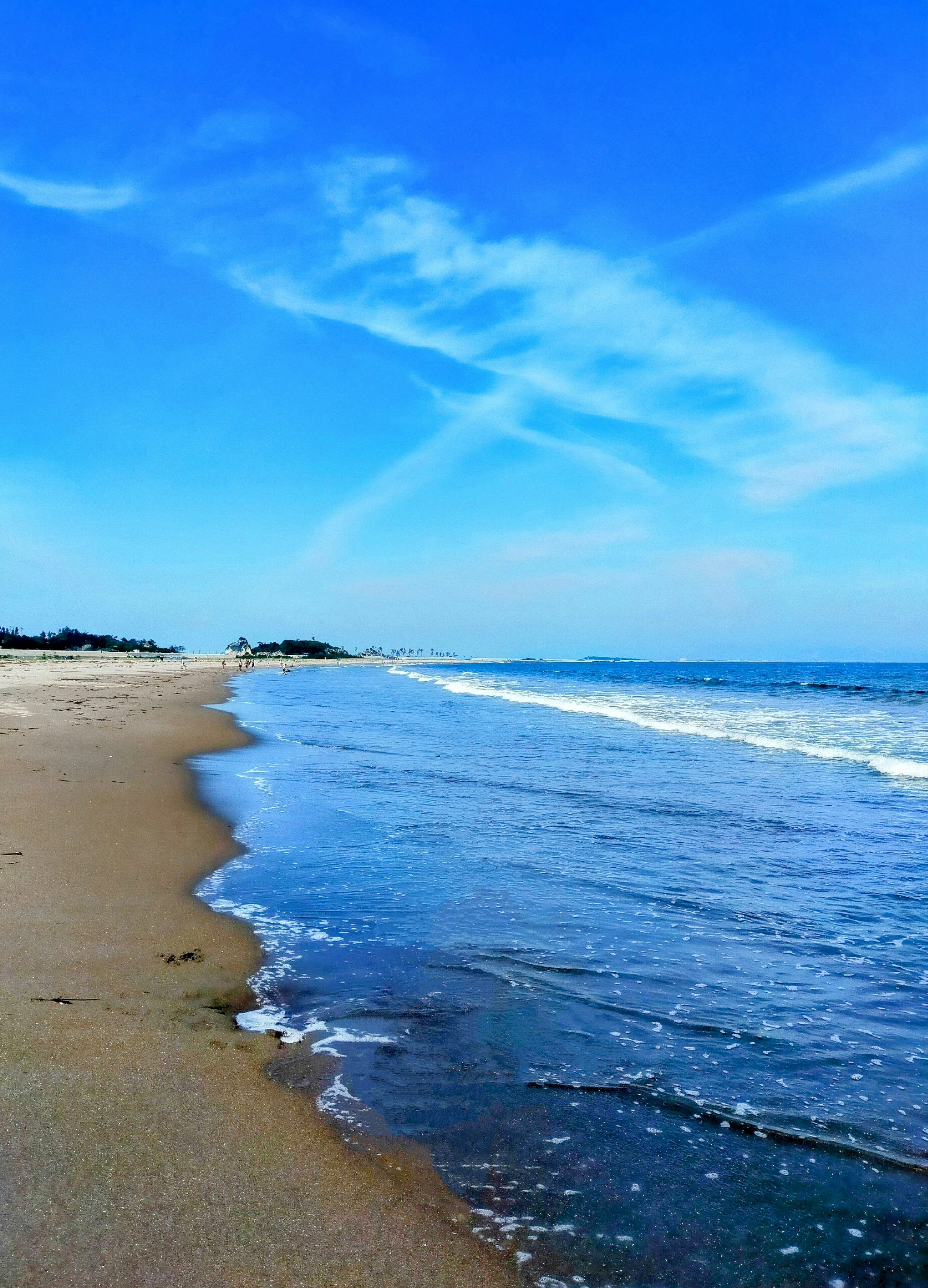 Pemandangan pantai dengan langit biru dan laut tenang