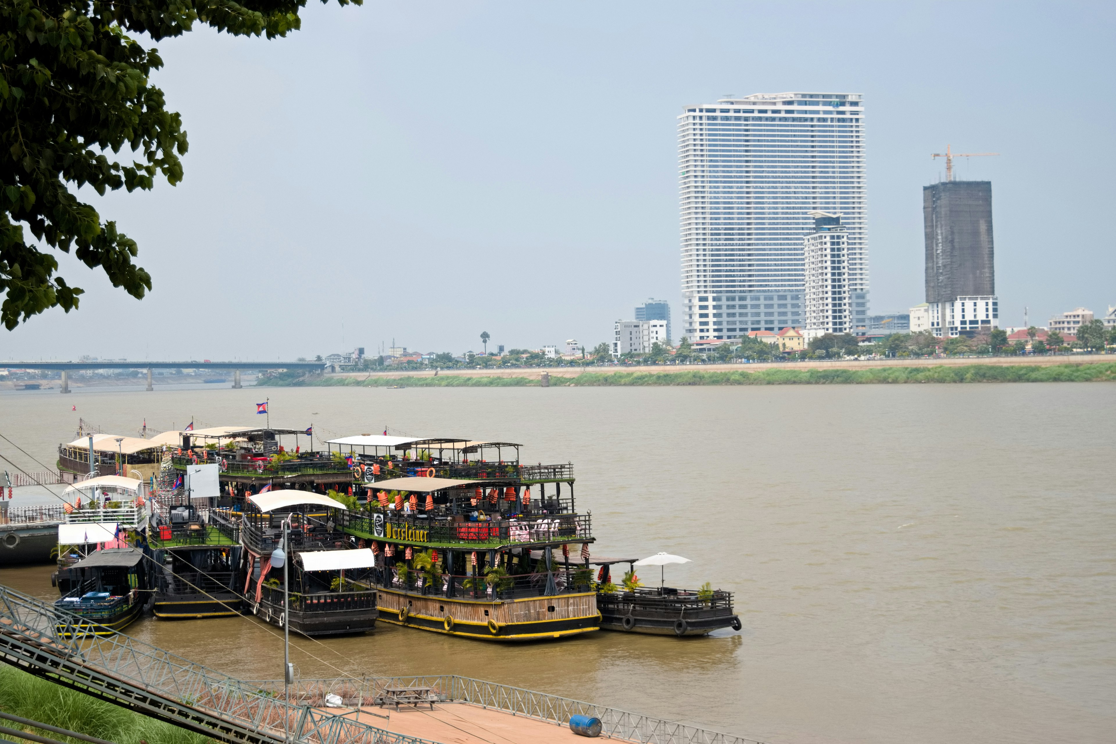 เรือริมแม่น้ำพร้อมอาคารสมัยใหม่ในพื้นหลัง