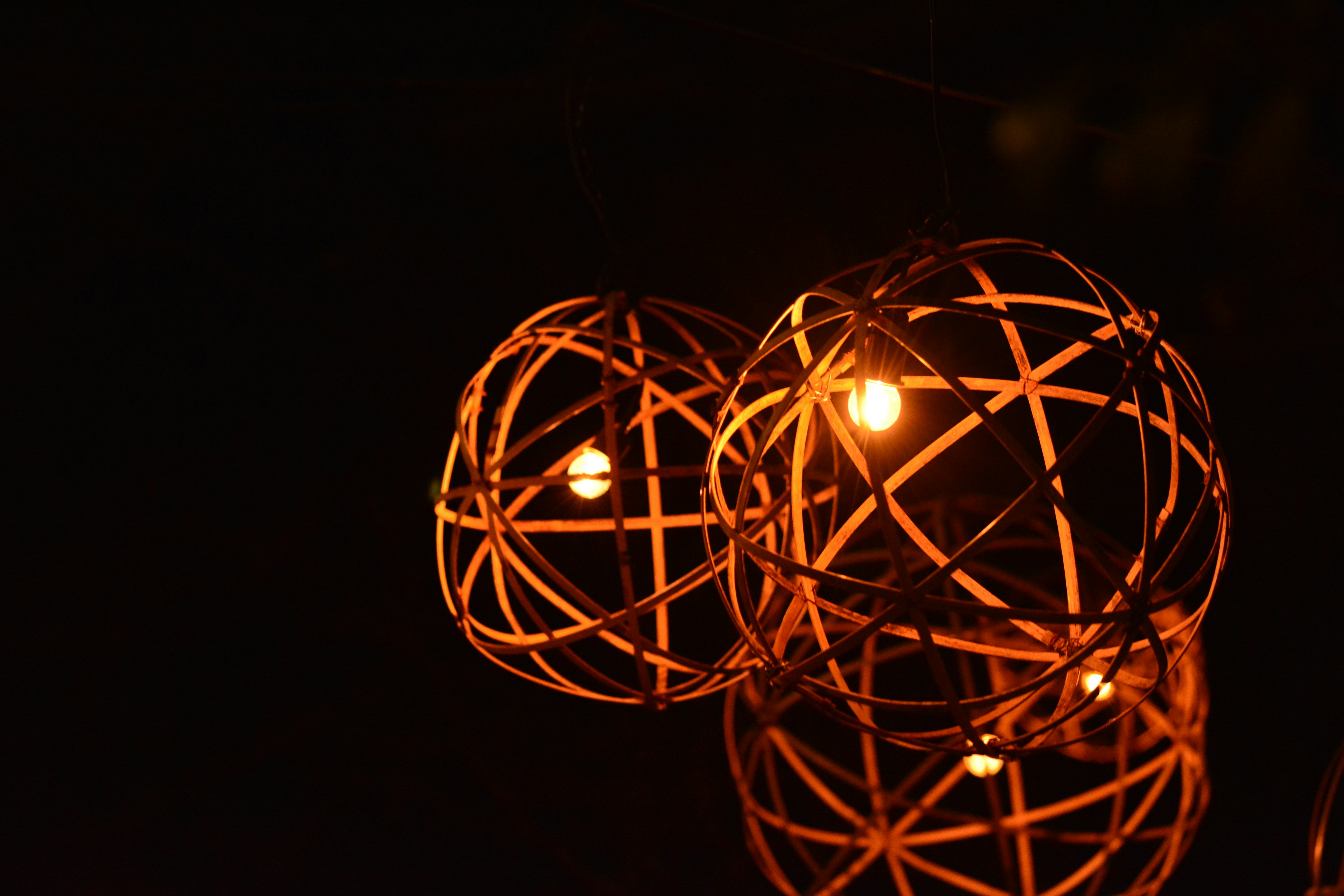 Rattan ball lamps glowing against a dark background