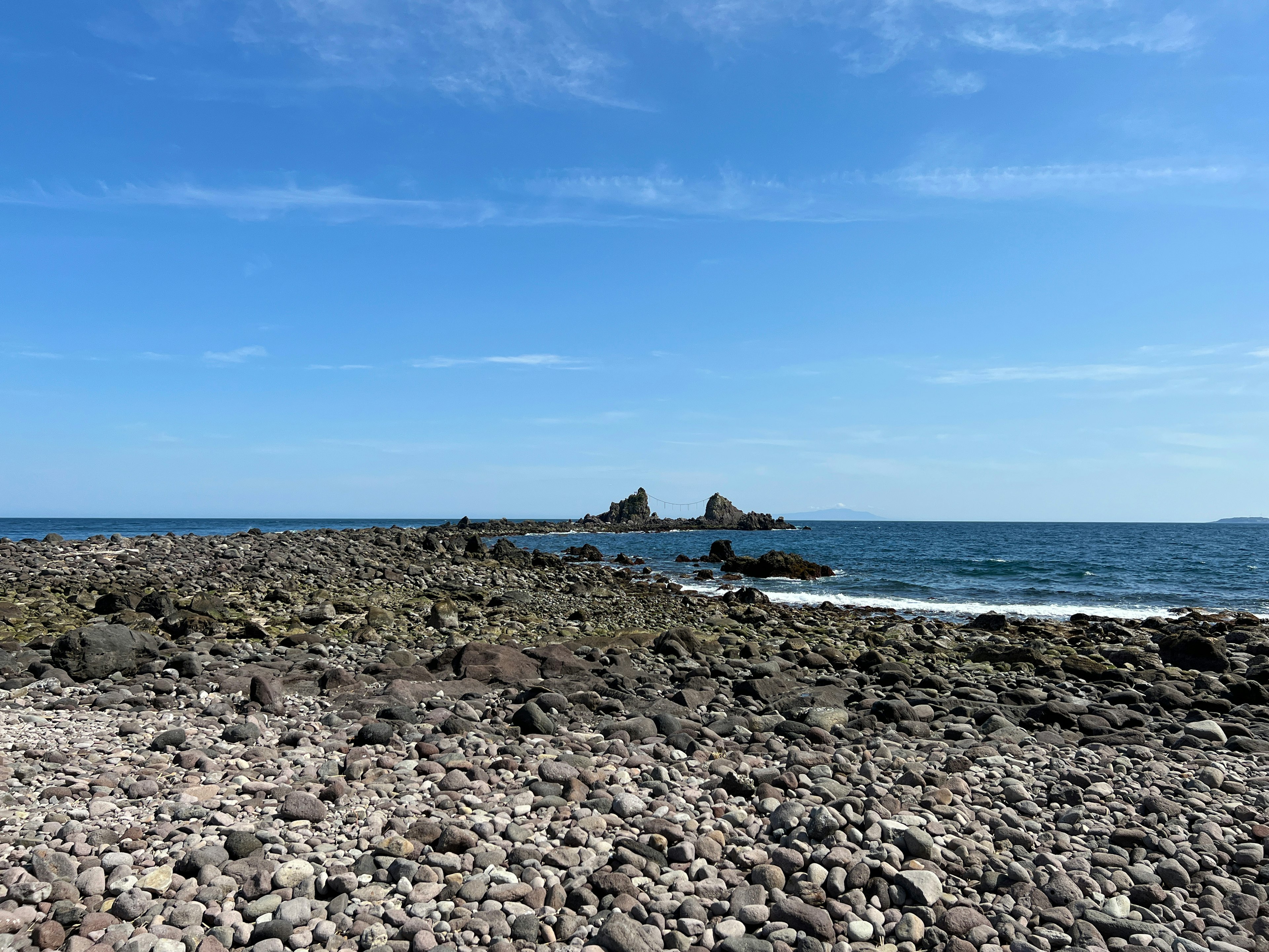 Costa rocciosa con piccole isole sotto un cielo blu