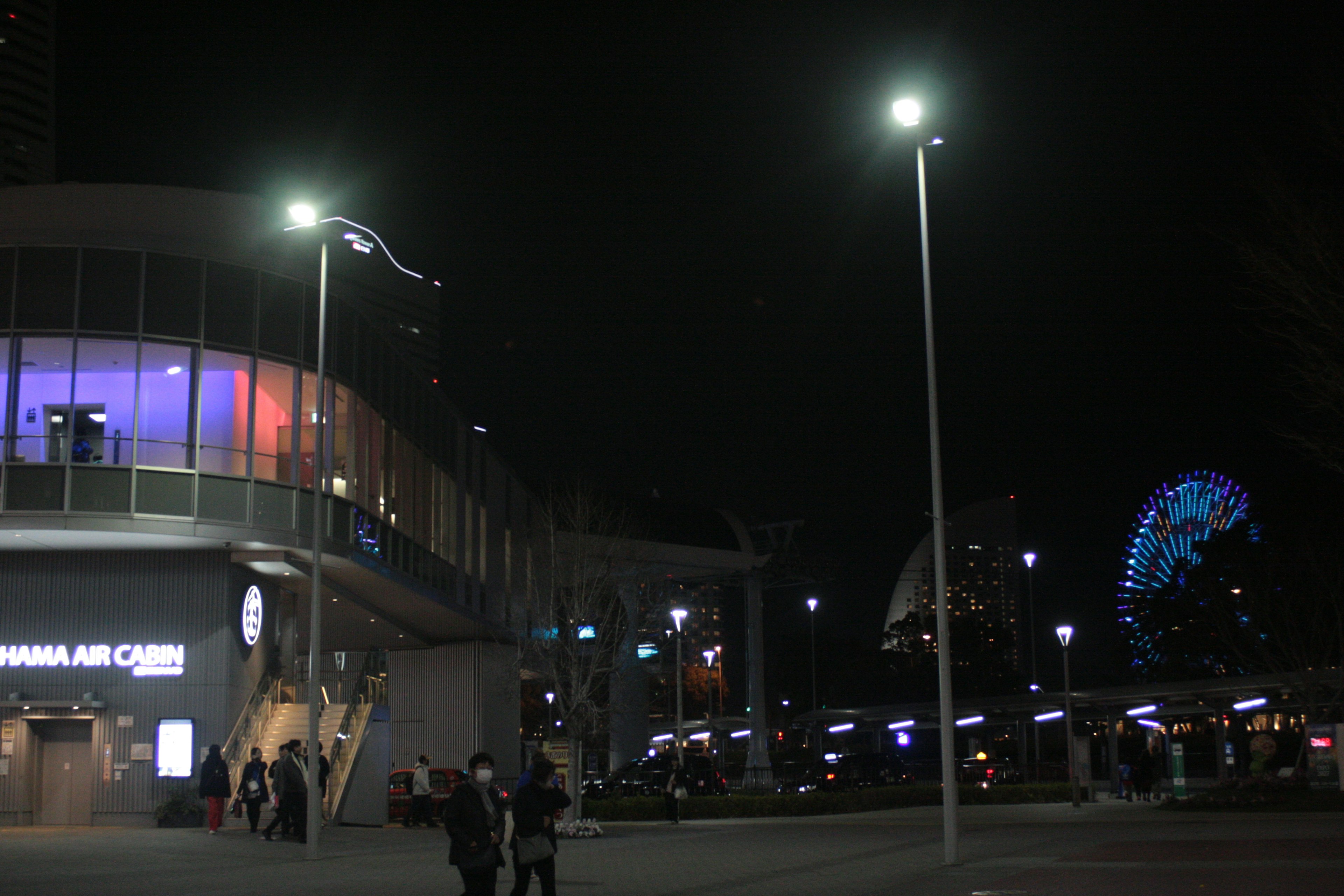 Escena urbana nocturna con un edificio moderno y una noria