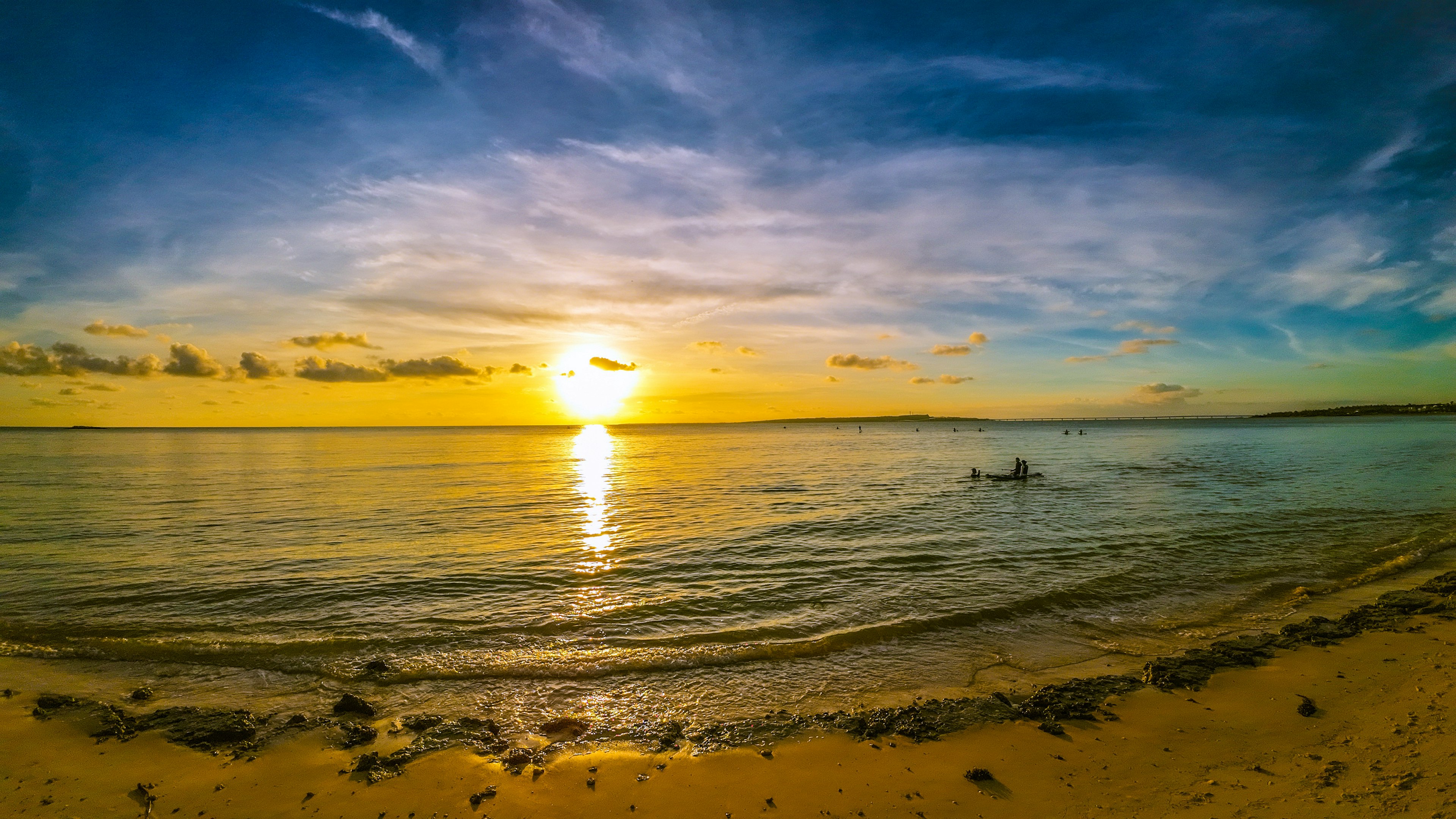 美しい夕日が海に沈みゆく風景 海岸の波と砂浜が広がる