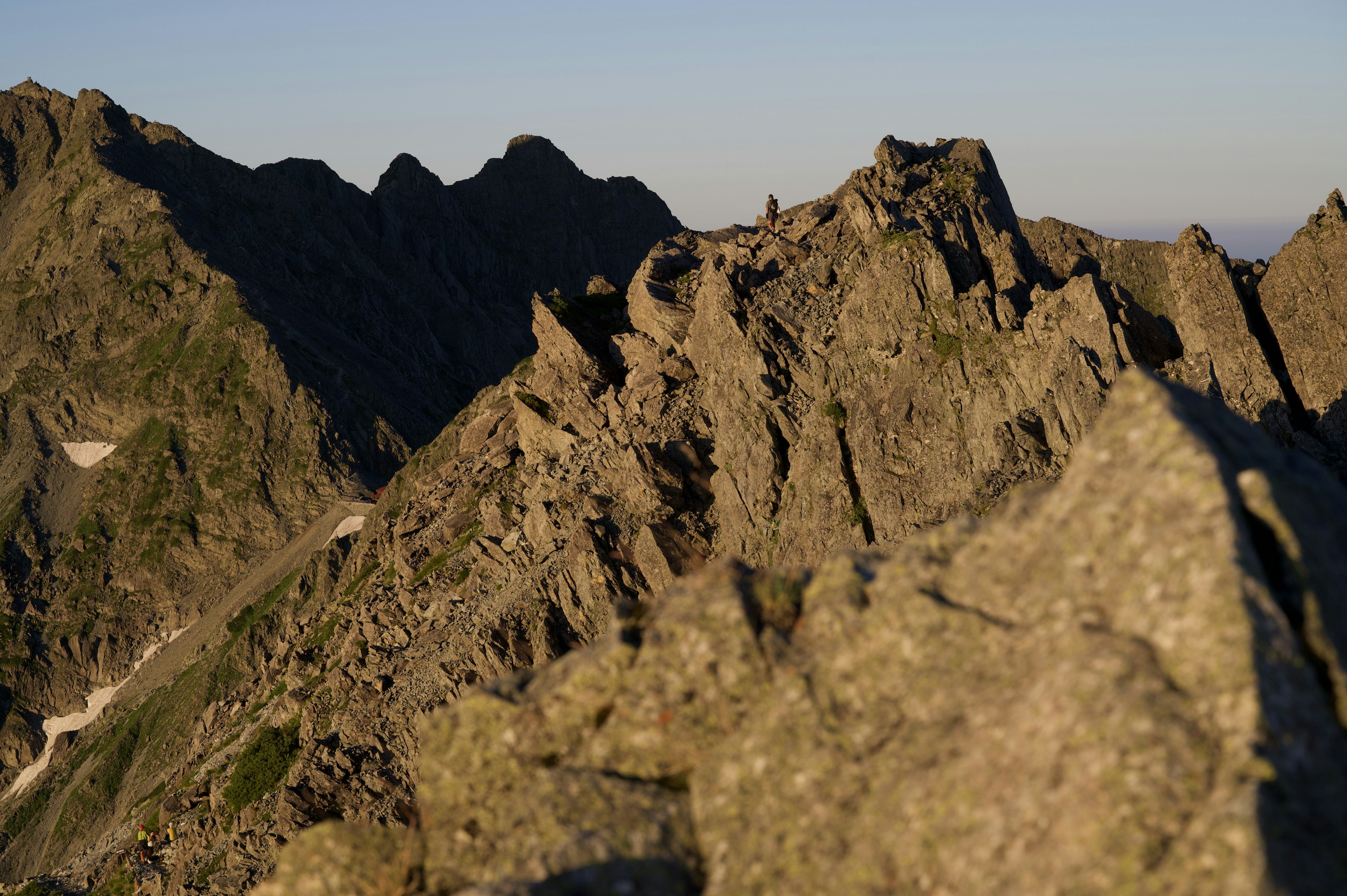 Scharfe Berggipfel, die im Licht der untergehenden Sonne leuchten