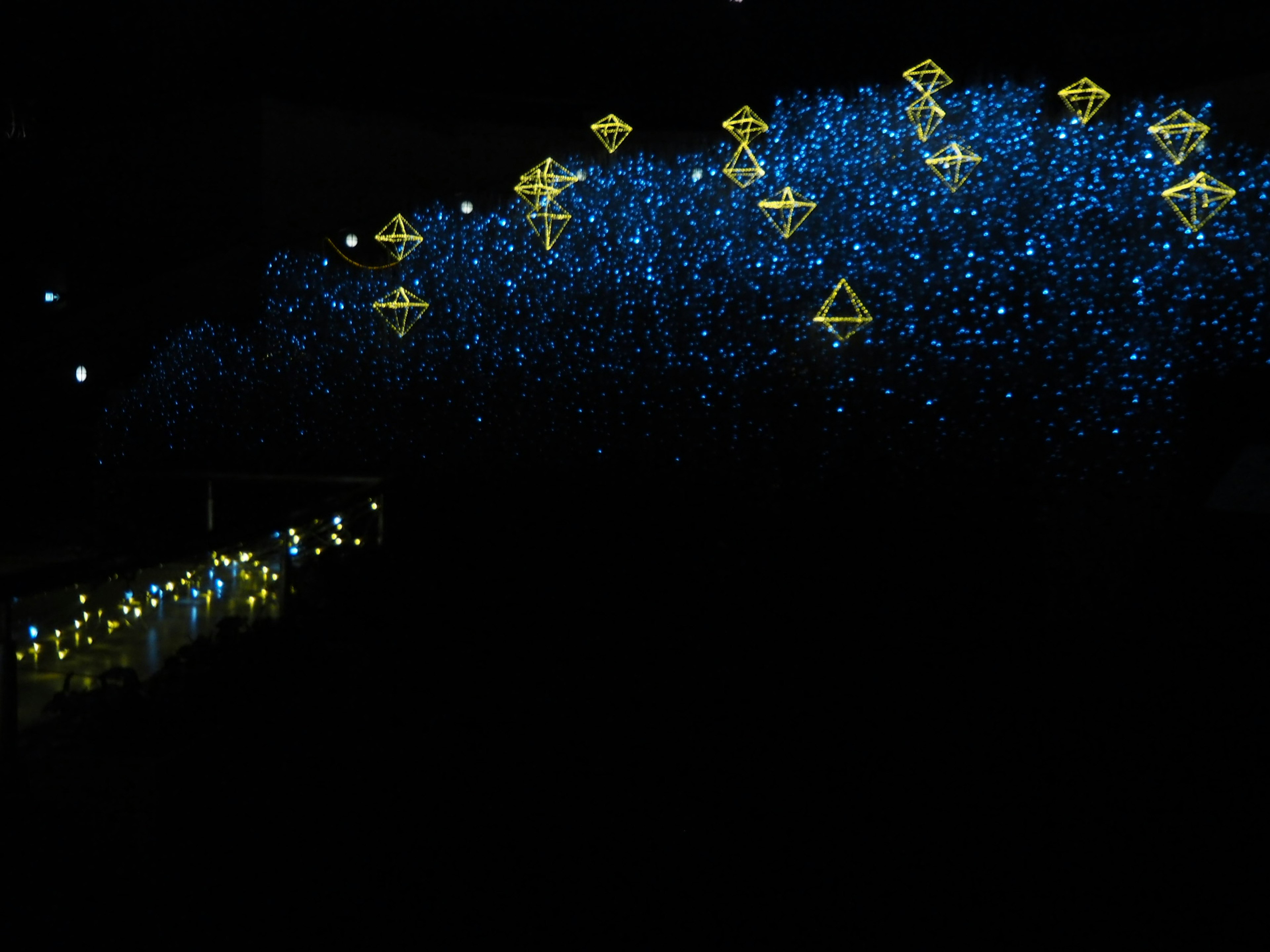 어두운 배경에 흩어져 있는 파란 불빛과 노란 형태의 매혹적인 장면