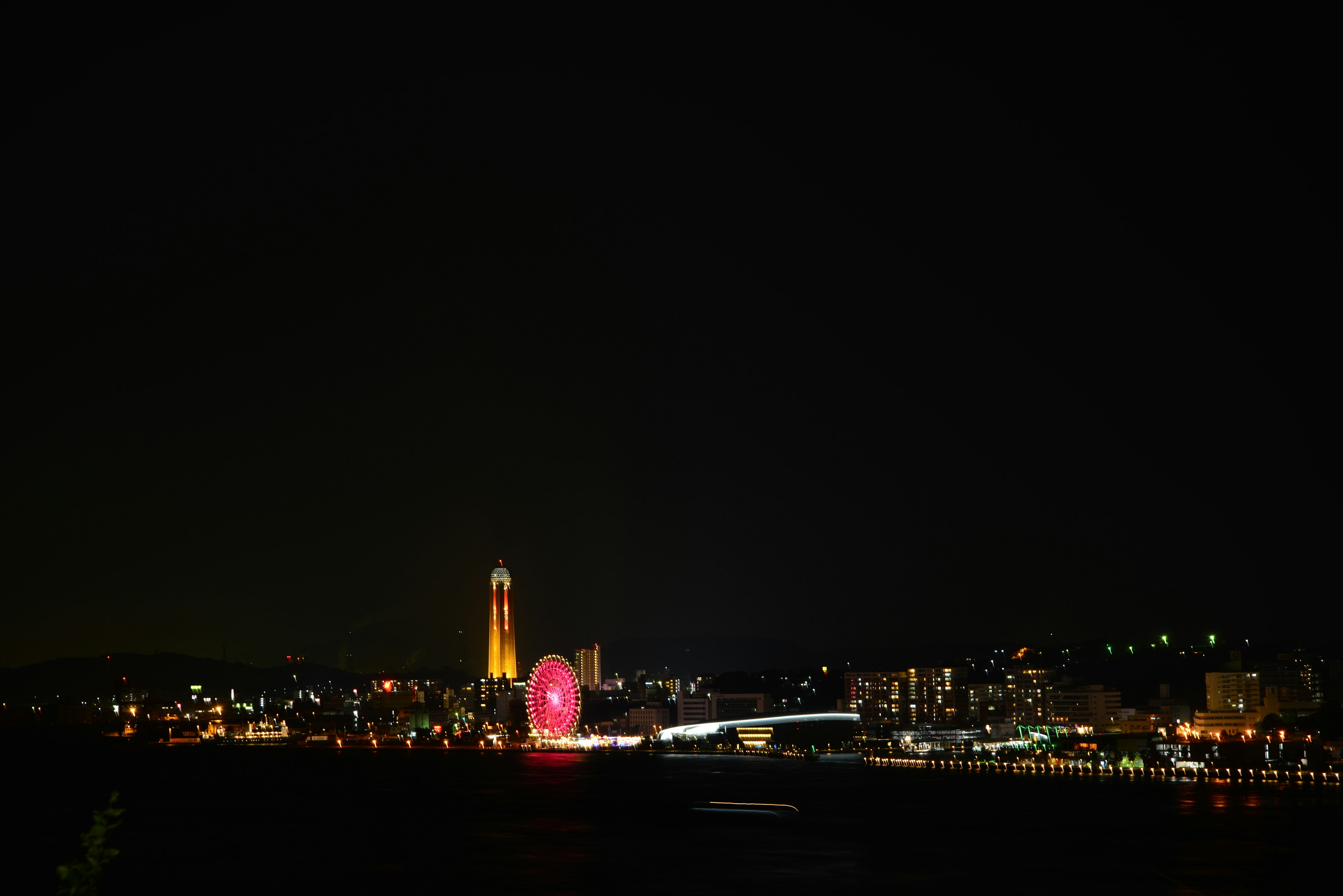 Nachtansicht einer Hafenstadt mit bunten Lichtern