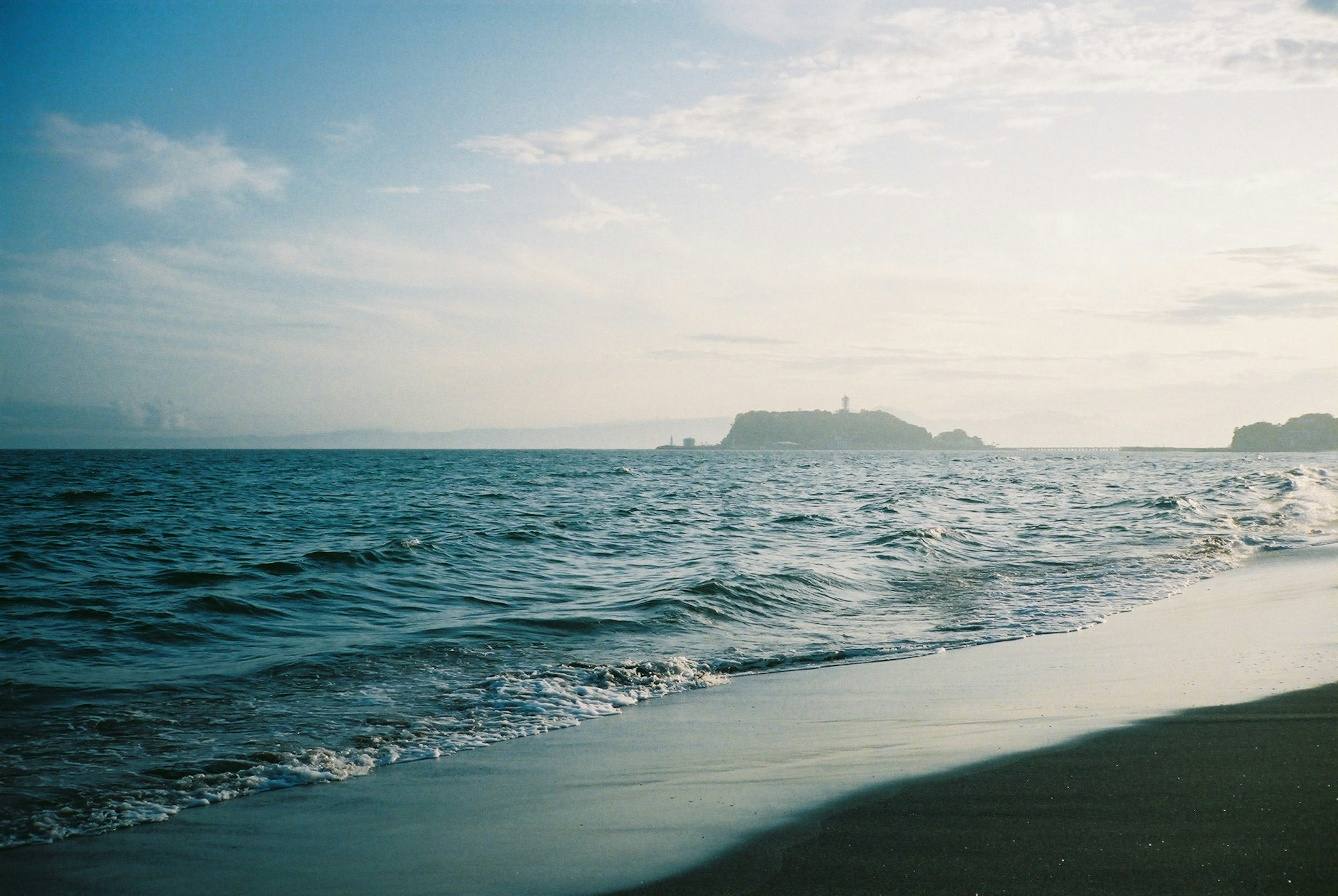 Scenic view of the ocean and sky with a distant island