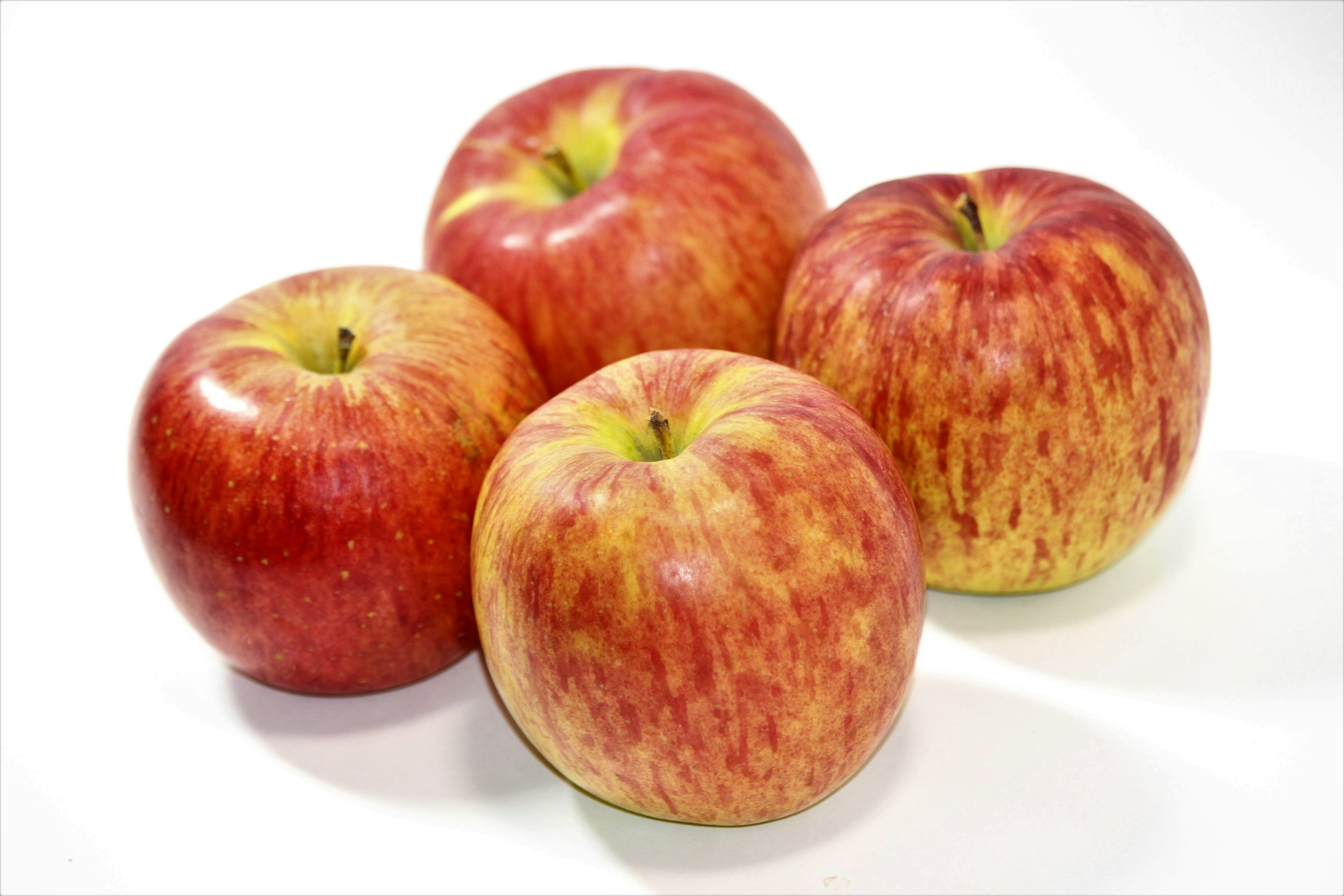 Four red apples arranged together