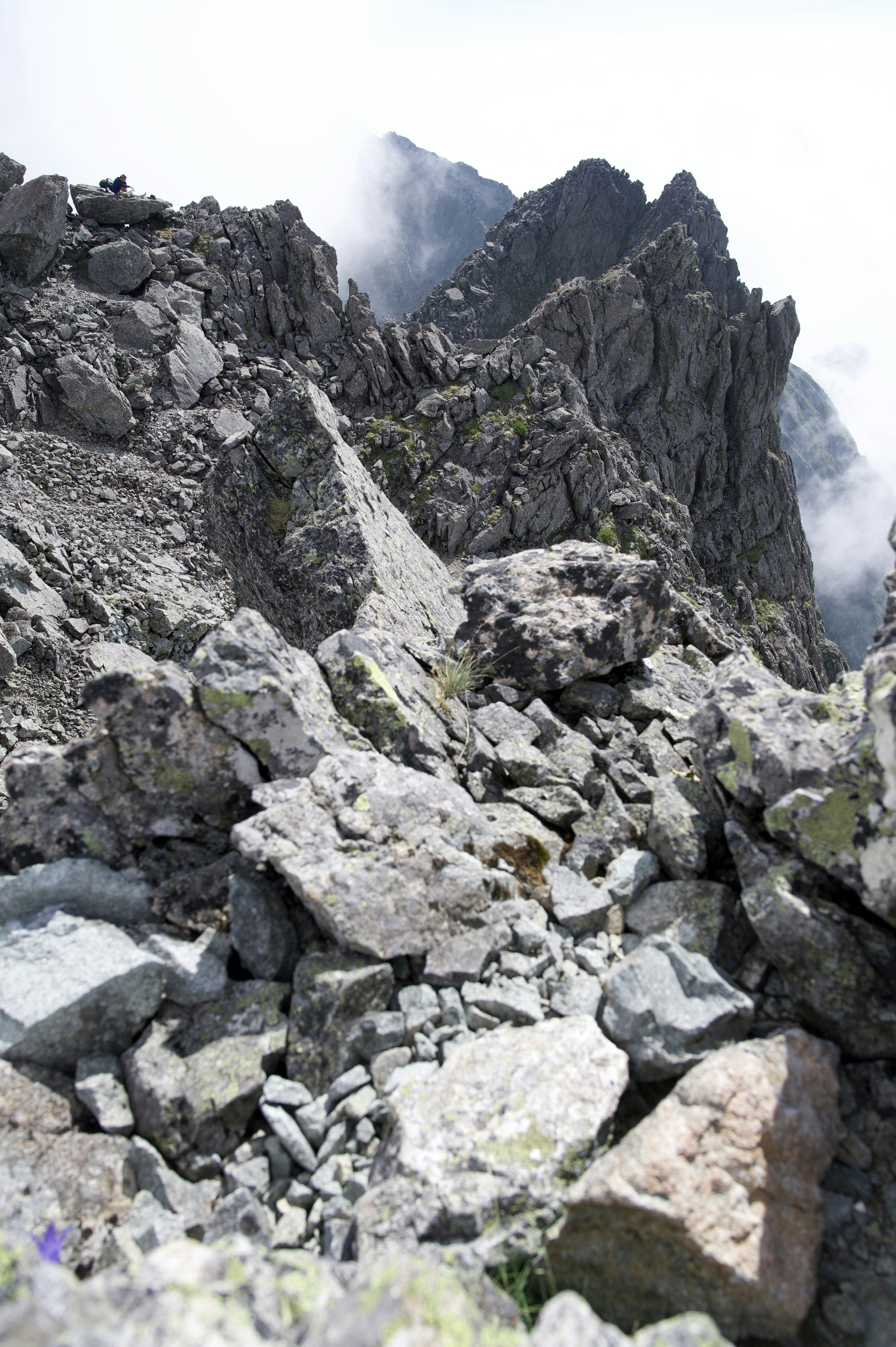 Felsige Berglandschaft mit verstreuten Steinen und Nebel