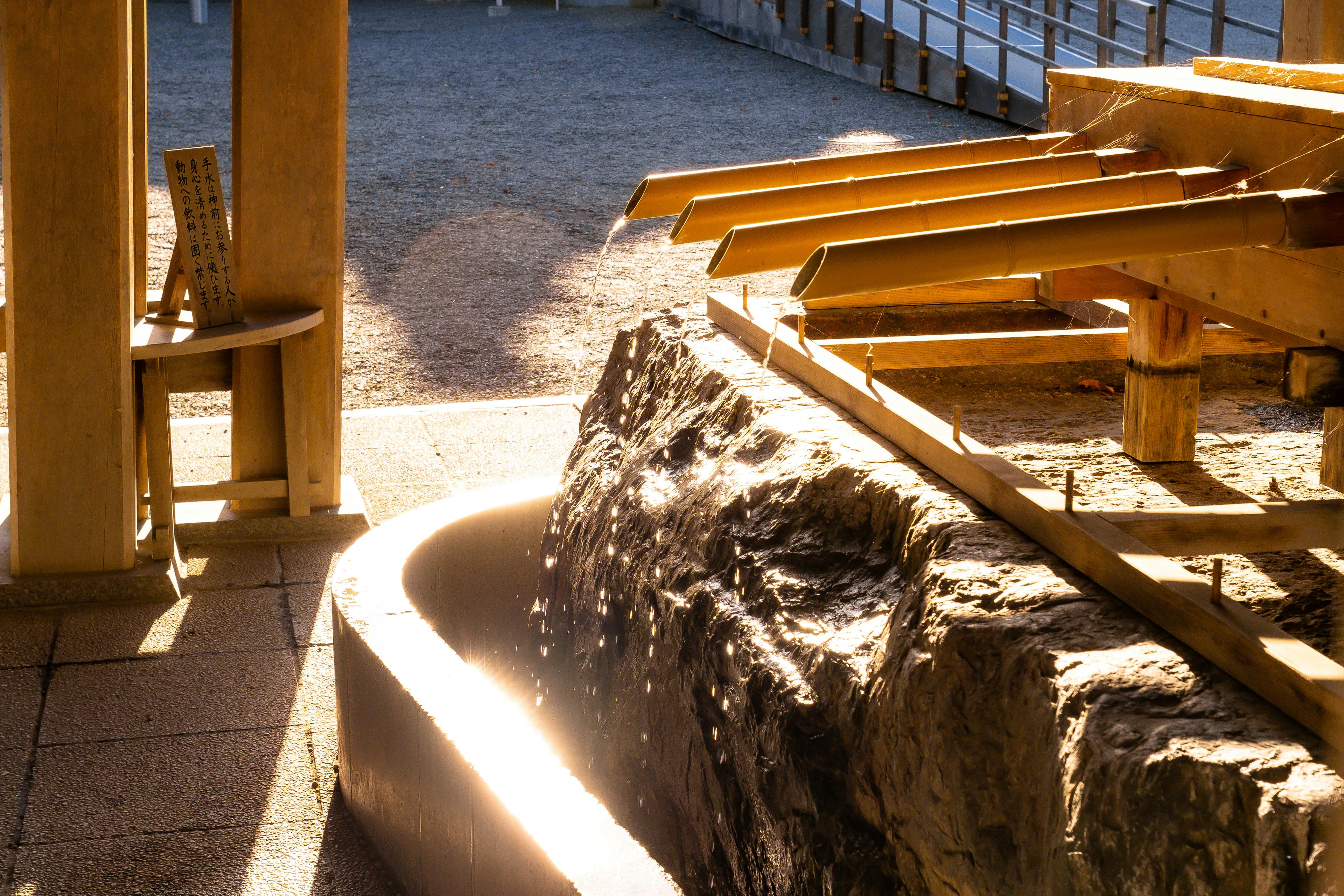 Ruhige Szene mit einem Holz-Wasserfluss-System und einem Steintrog