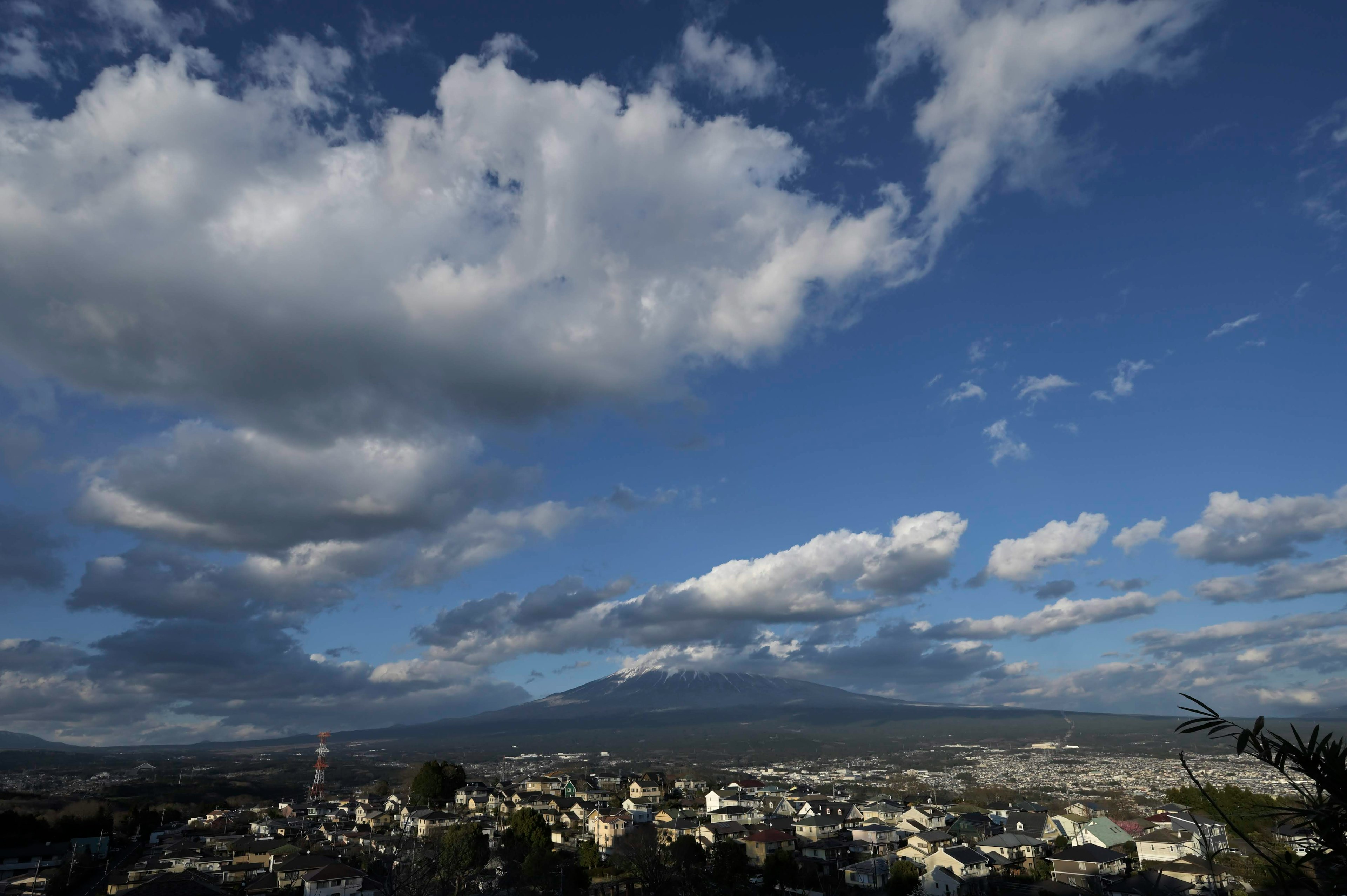 青空と白い雲が広がる風景 山と街が見える