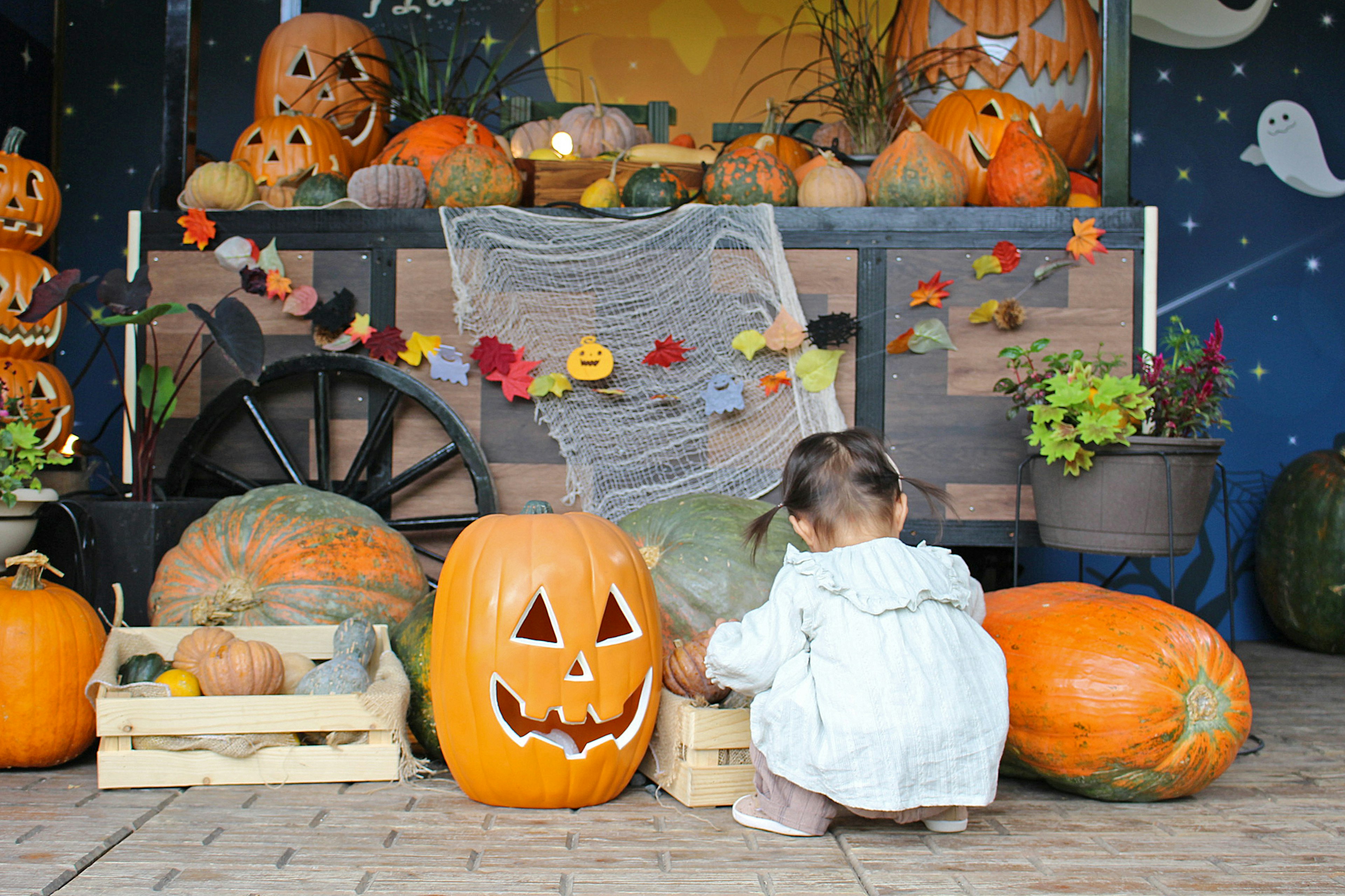 Ein Kind spielt vor einer Halloween-Kürbisausstellung