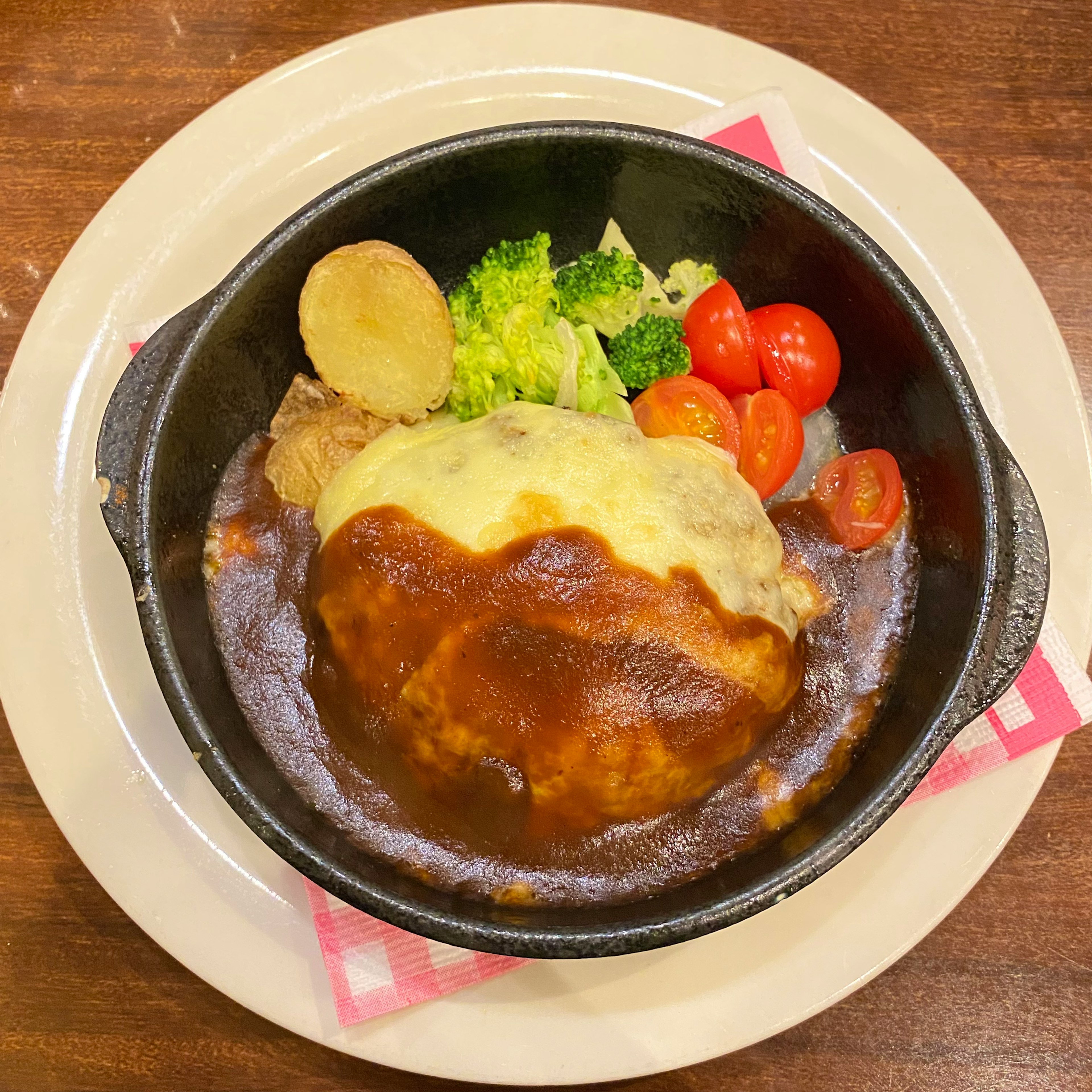 Omelettreis in einem schwarzen Topf mit Demi-Glace-Sauce garniert mit Brokkoli und Kirschtomaten