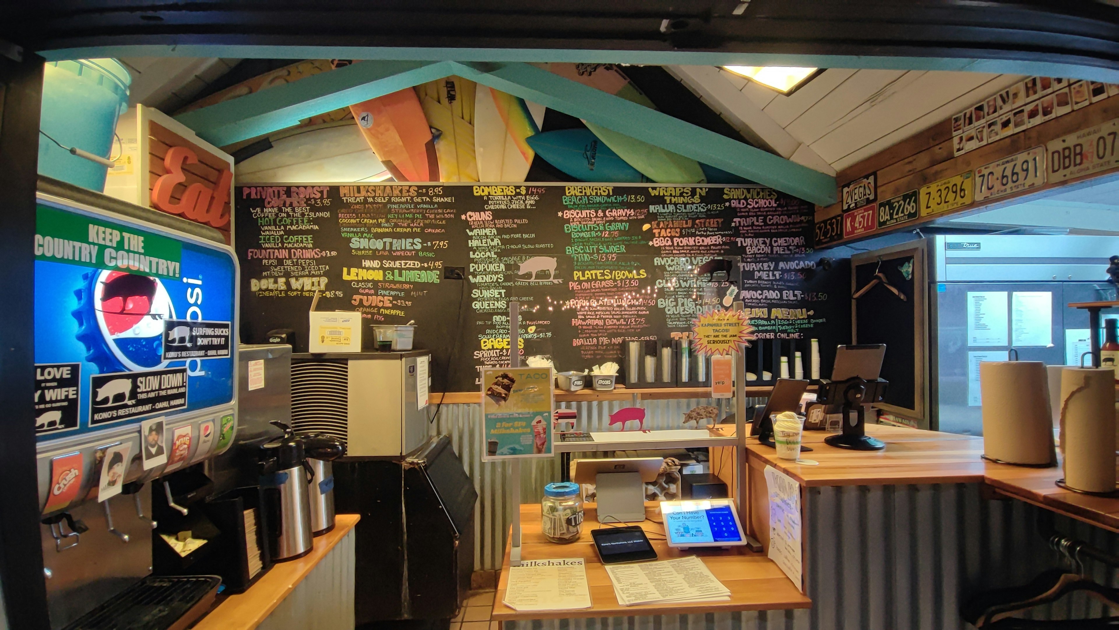 Interior kafe yang cerah dengan meja dan menu papan tulis