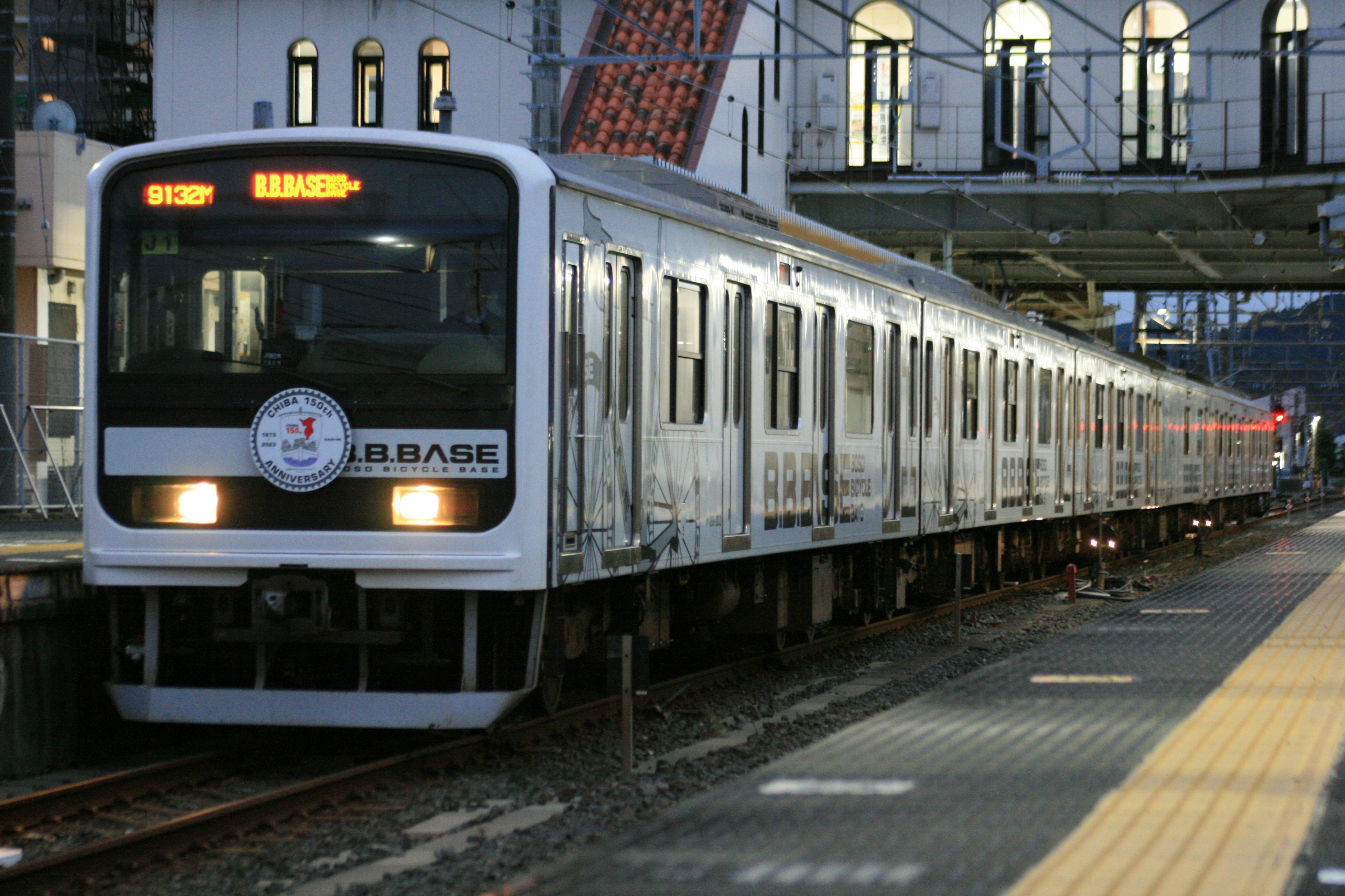 Weißer Zug hält an einer Station in der Dämmerung